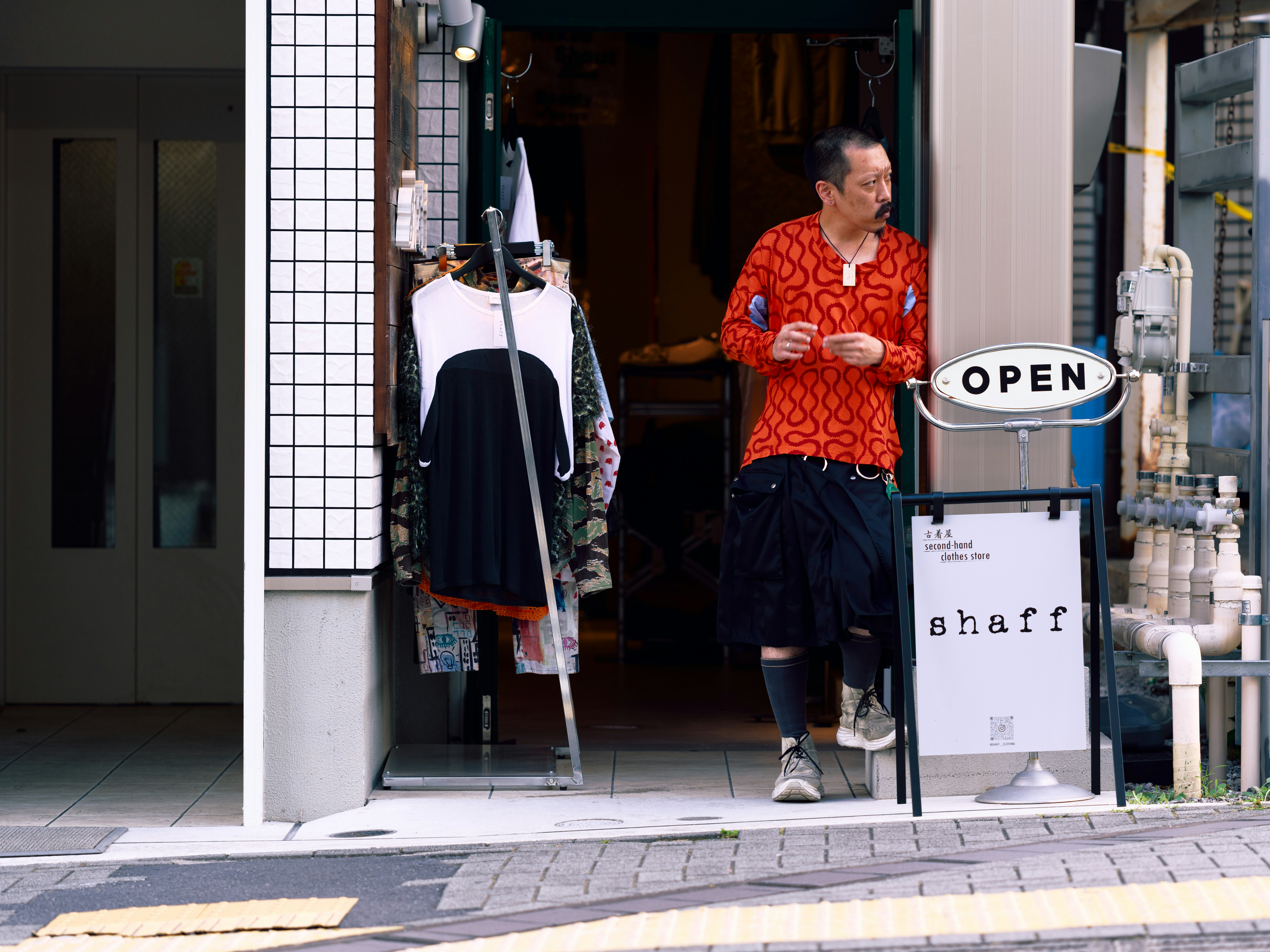Man in patterned shirt by open entrance