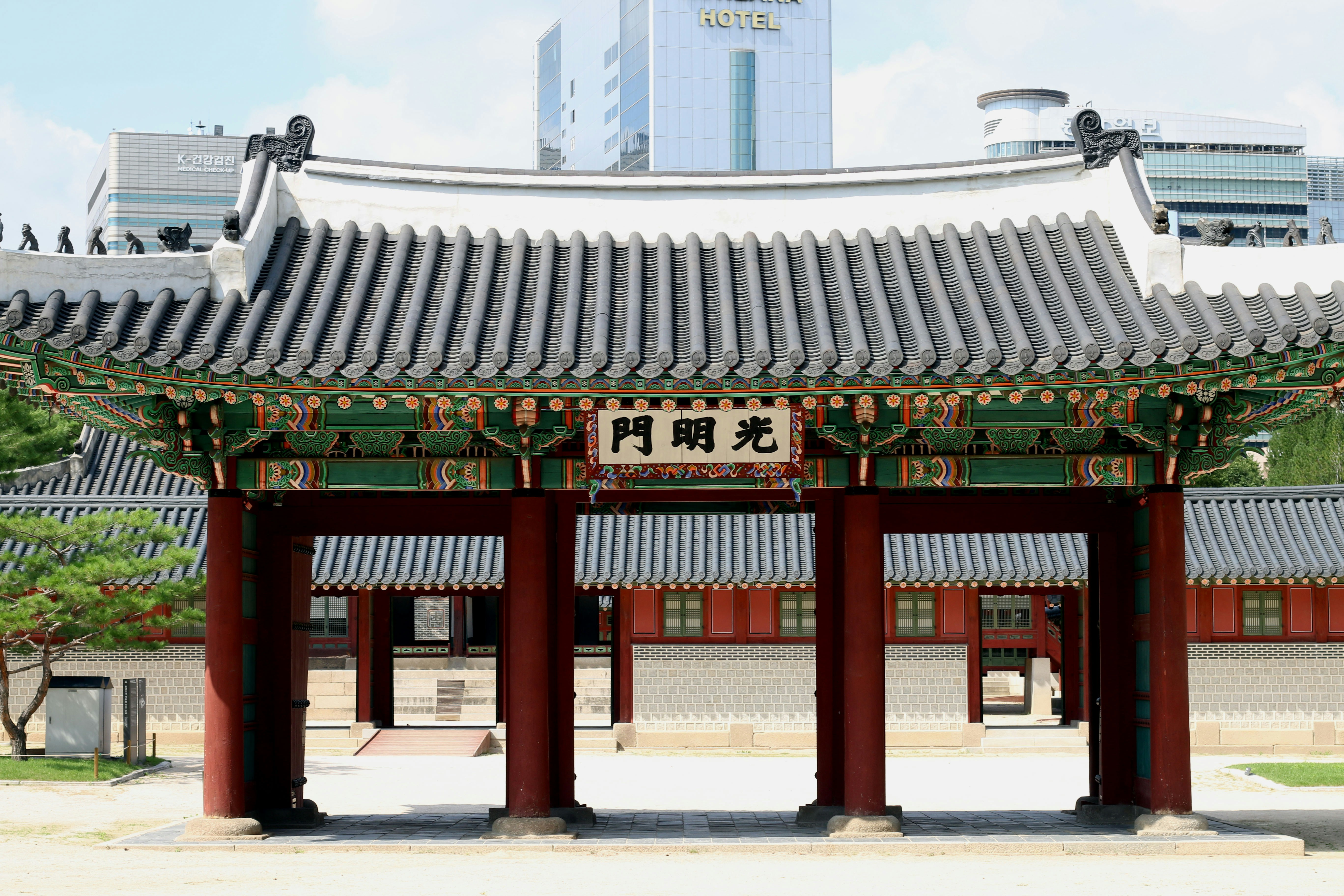 Traditional korean palace gate with modern buildings in background