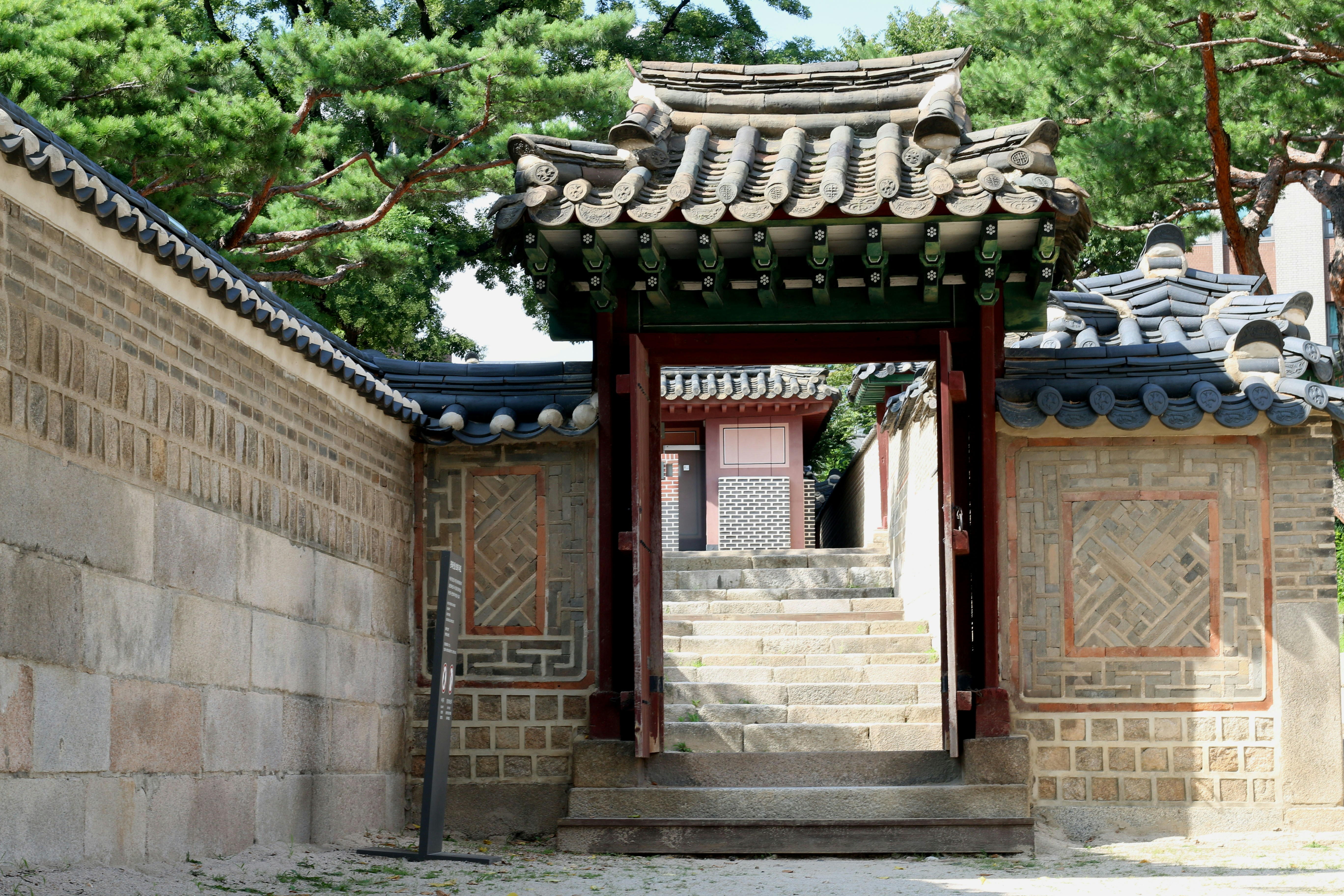 Traditional korean gate with a tiled roof and stone wall
