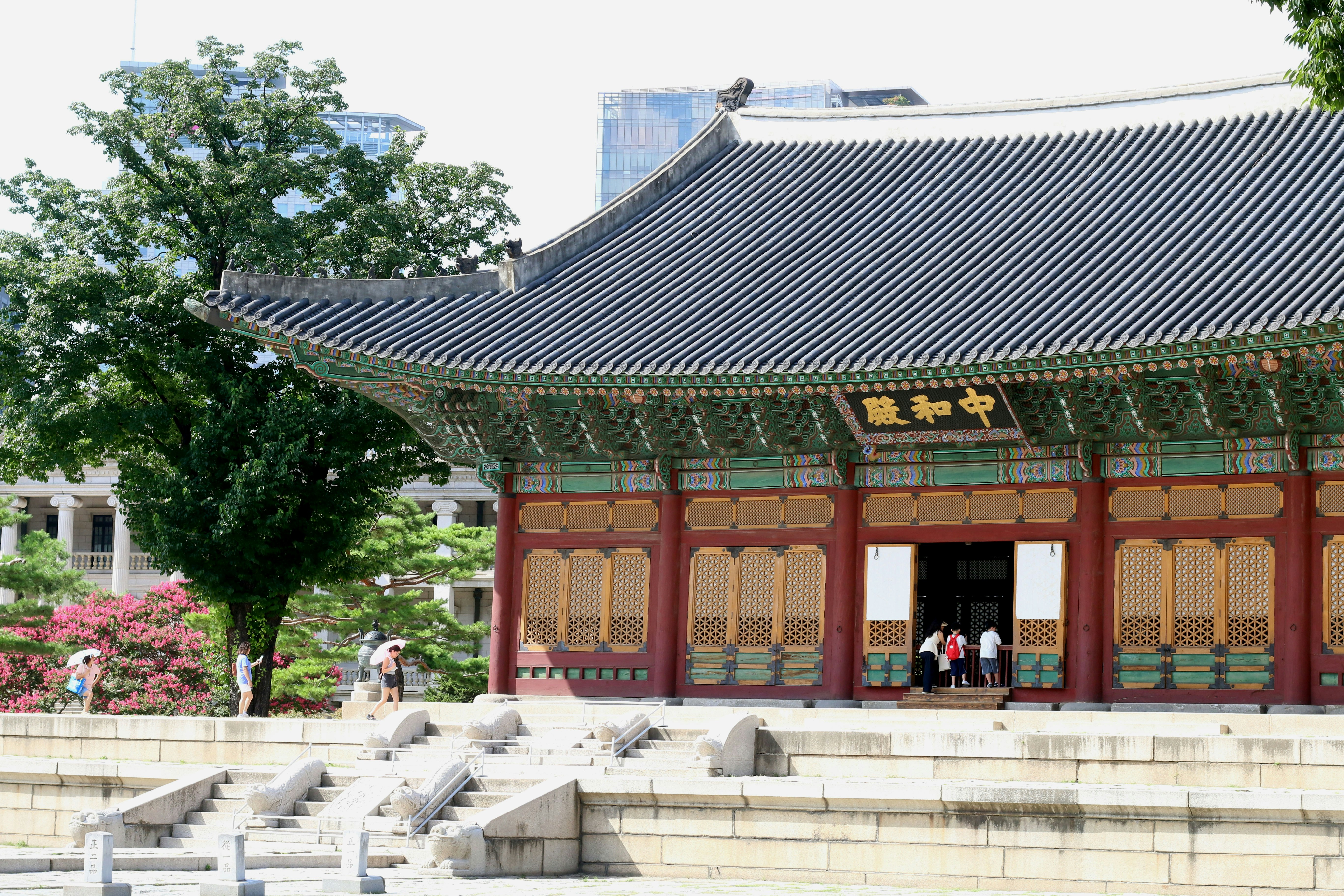 Historic korean palace building with ornate roof and visitors