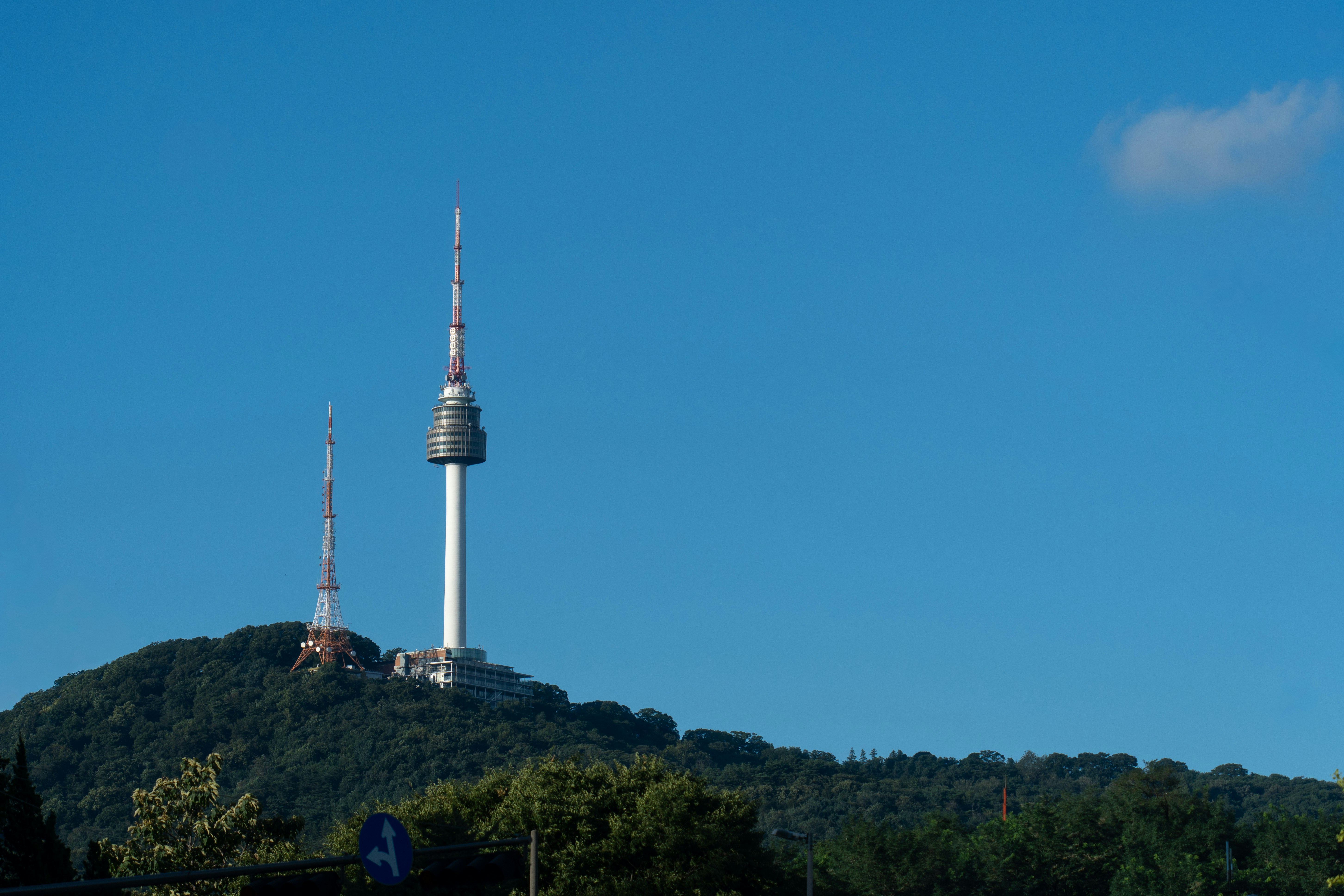 N seoul tower and another tower on a forested hill.