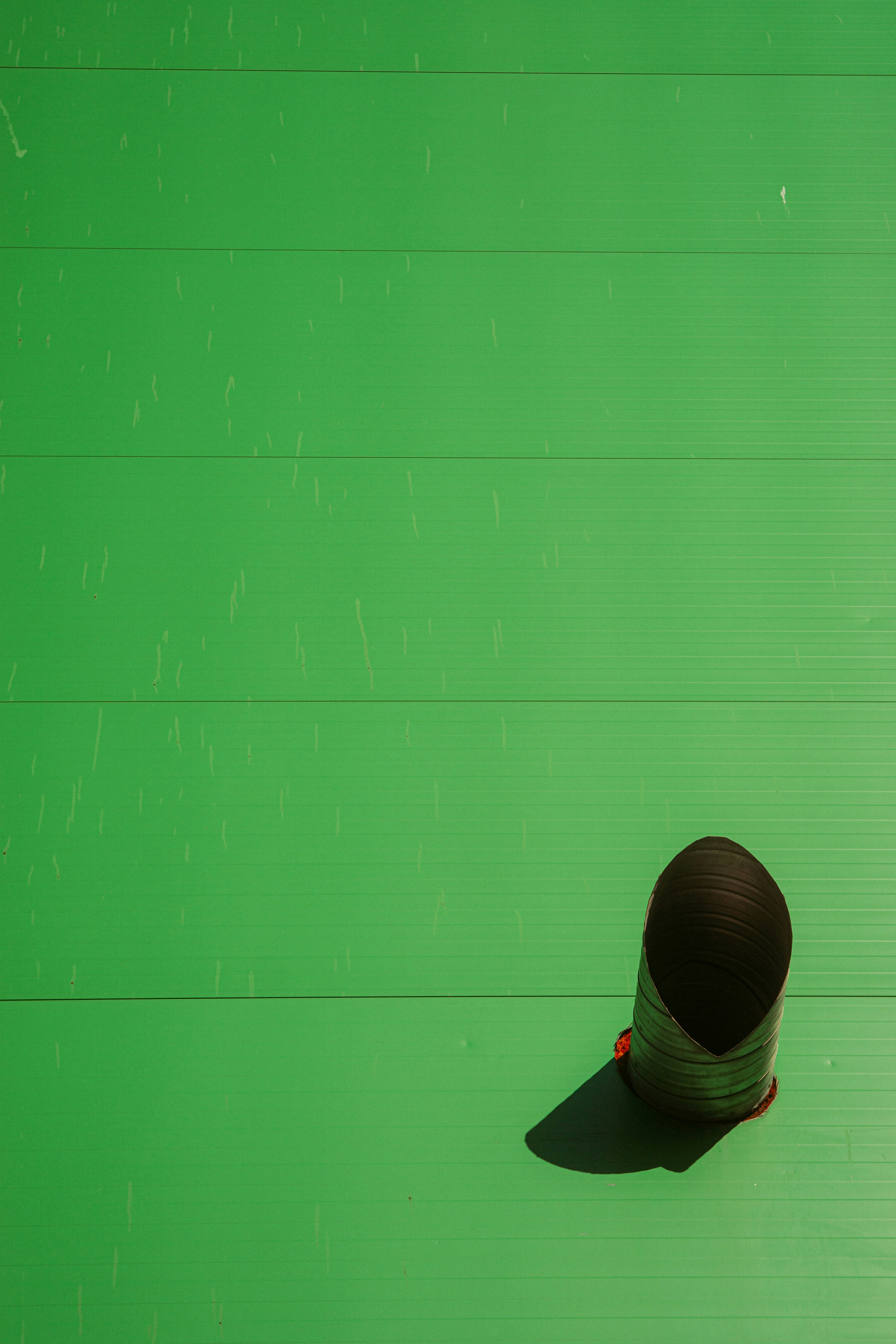 A dark, cone-shaped object on a green striped background.