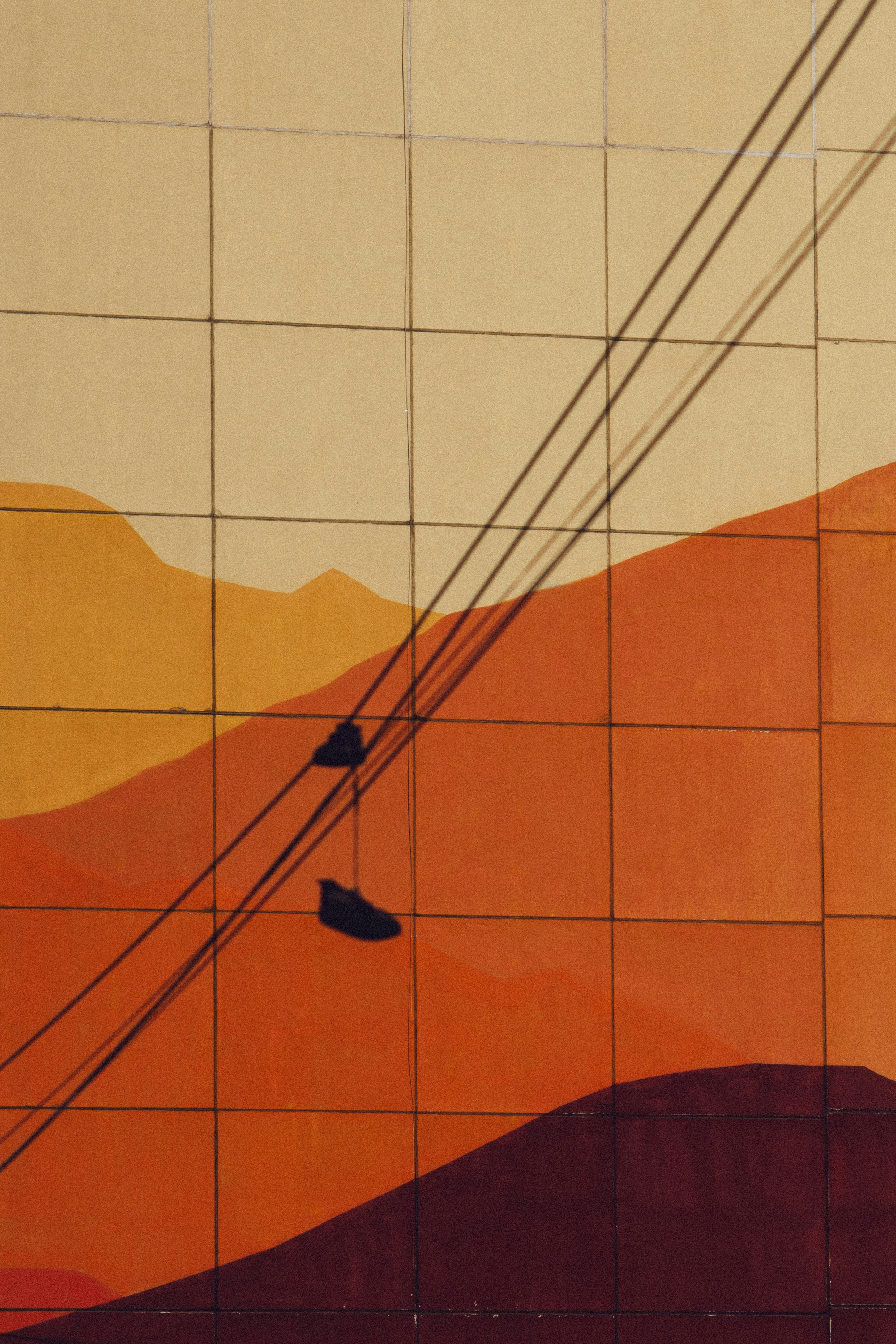 Abstract mural with layered orange hills and diagonal shadows.