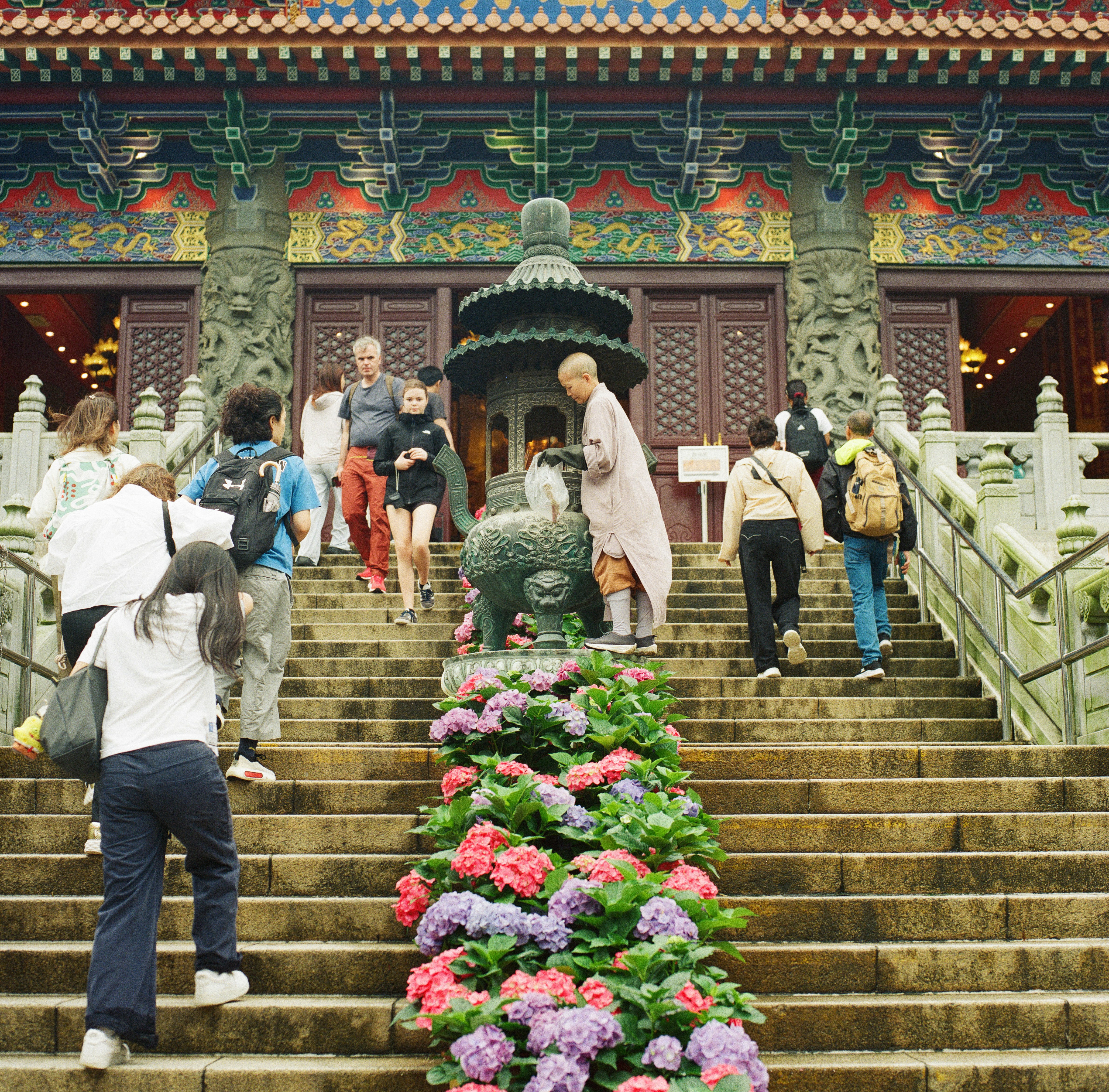 Visitors walk up temple stairs decorated with flowers