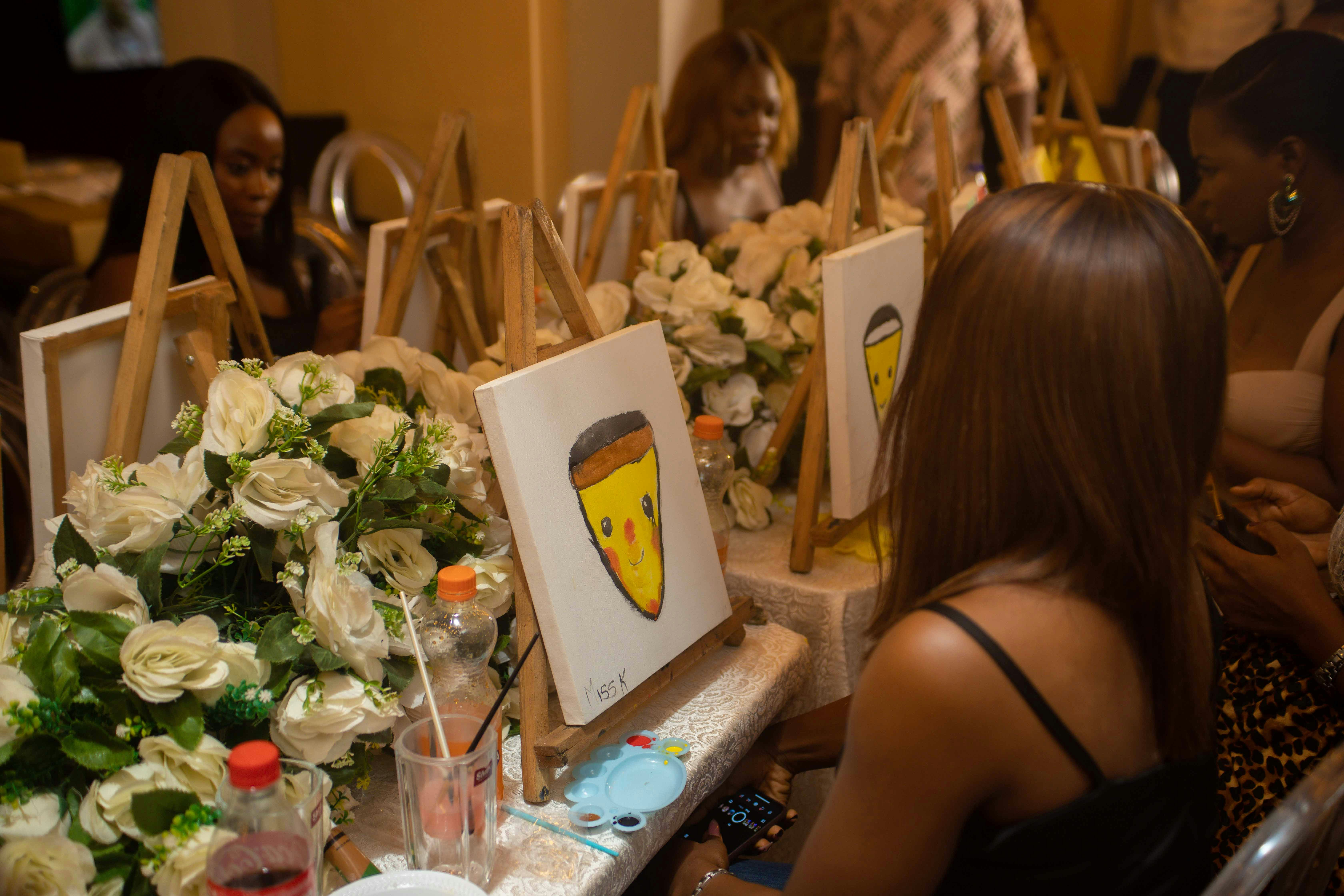 A woman painting a cartoon face at an art event
