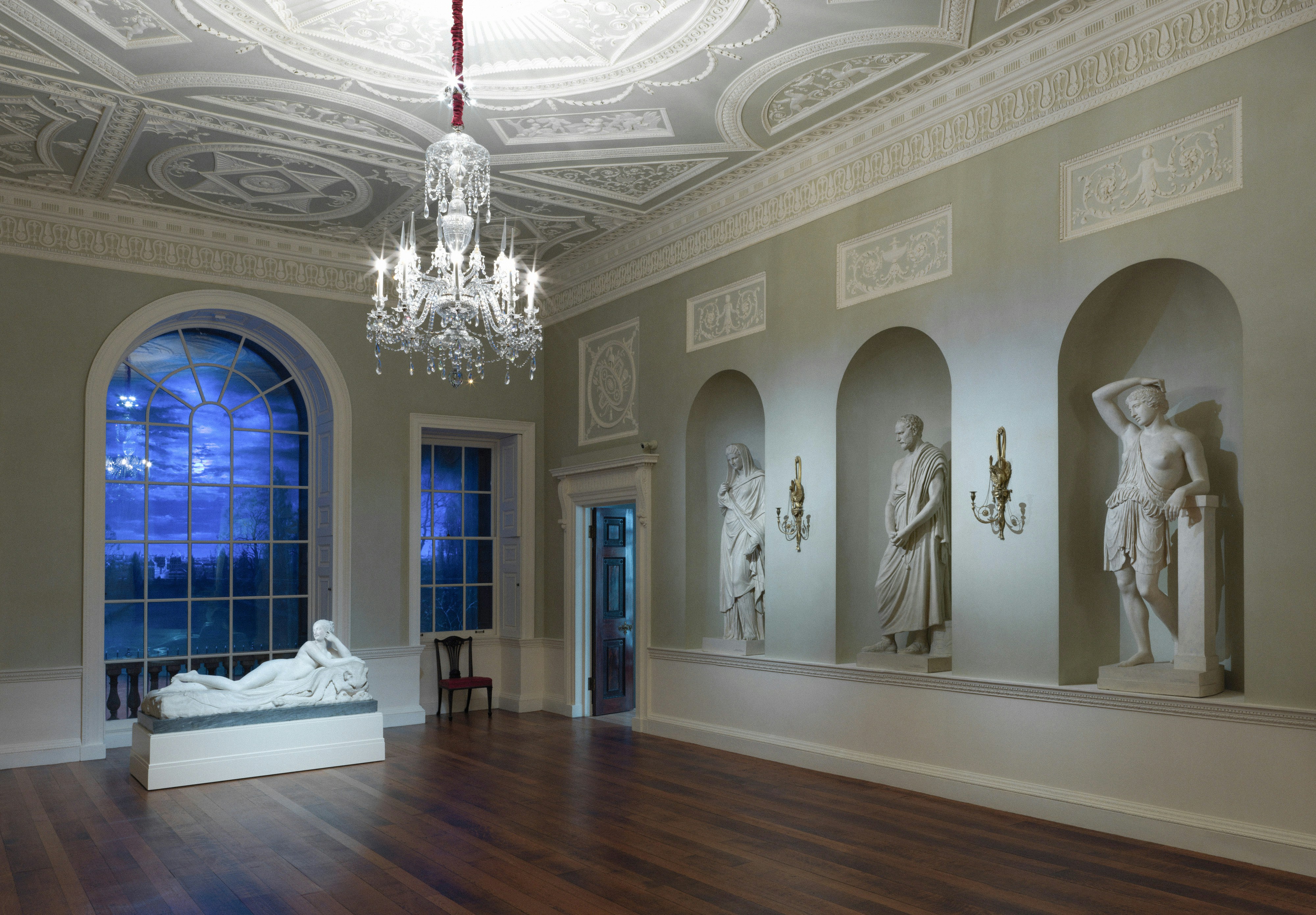 Elegant room with chandelier and classical statues