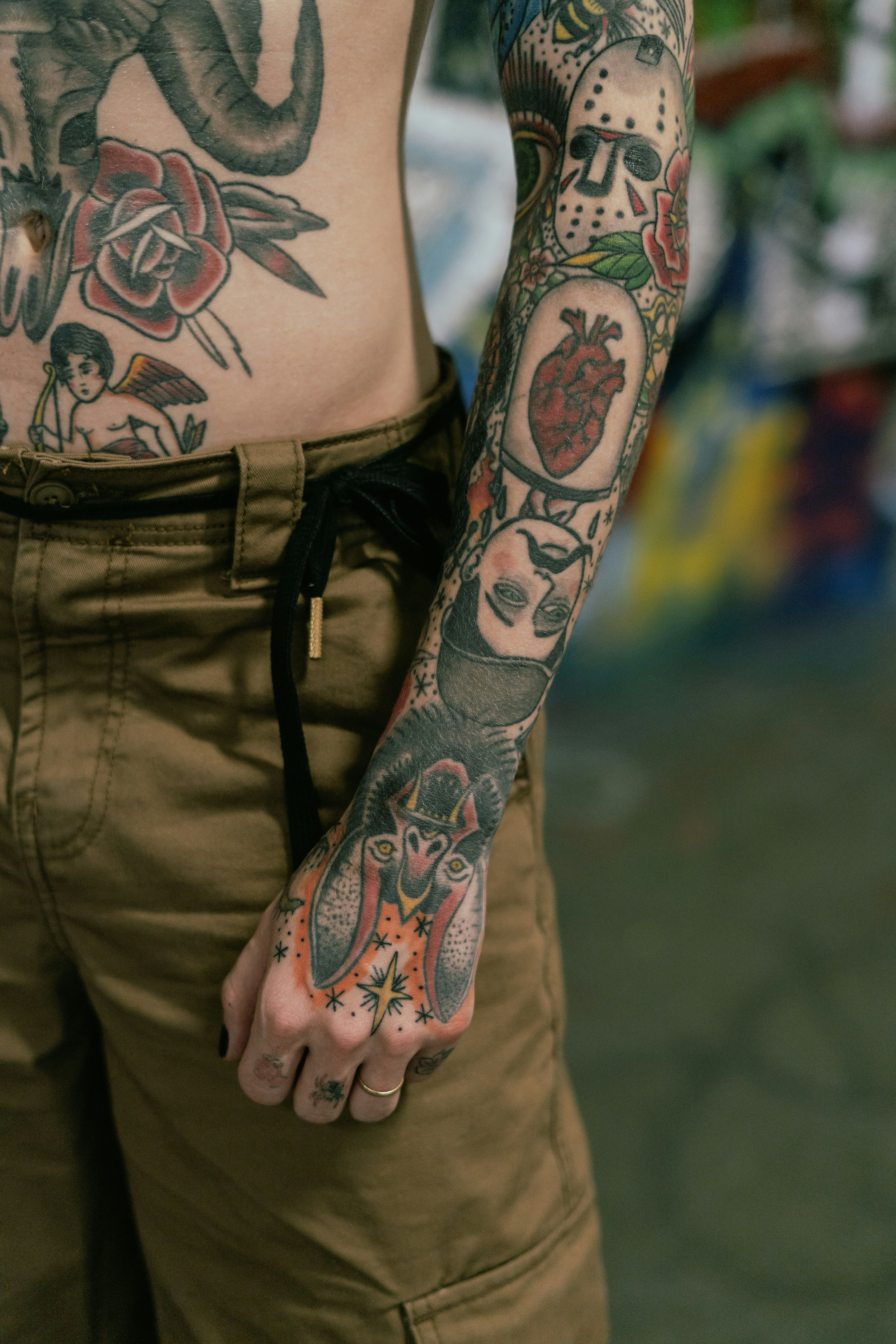 Person's arm and torso covered in intricate tattoos