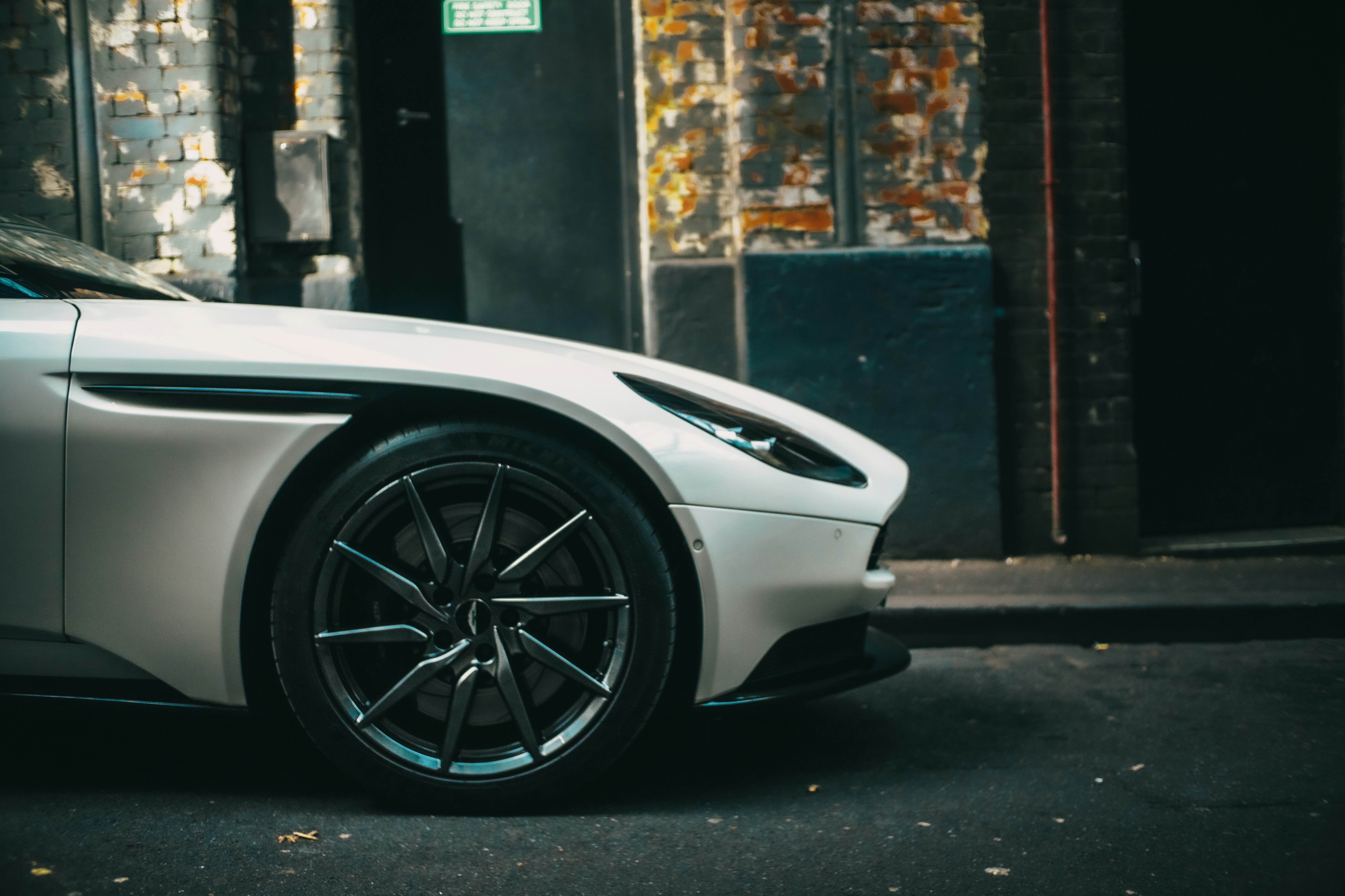 Sleek white sports car parked on a gritty city street.