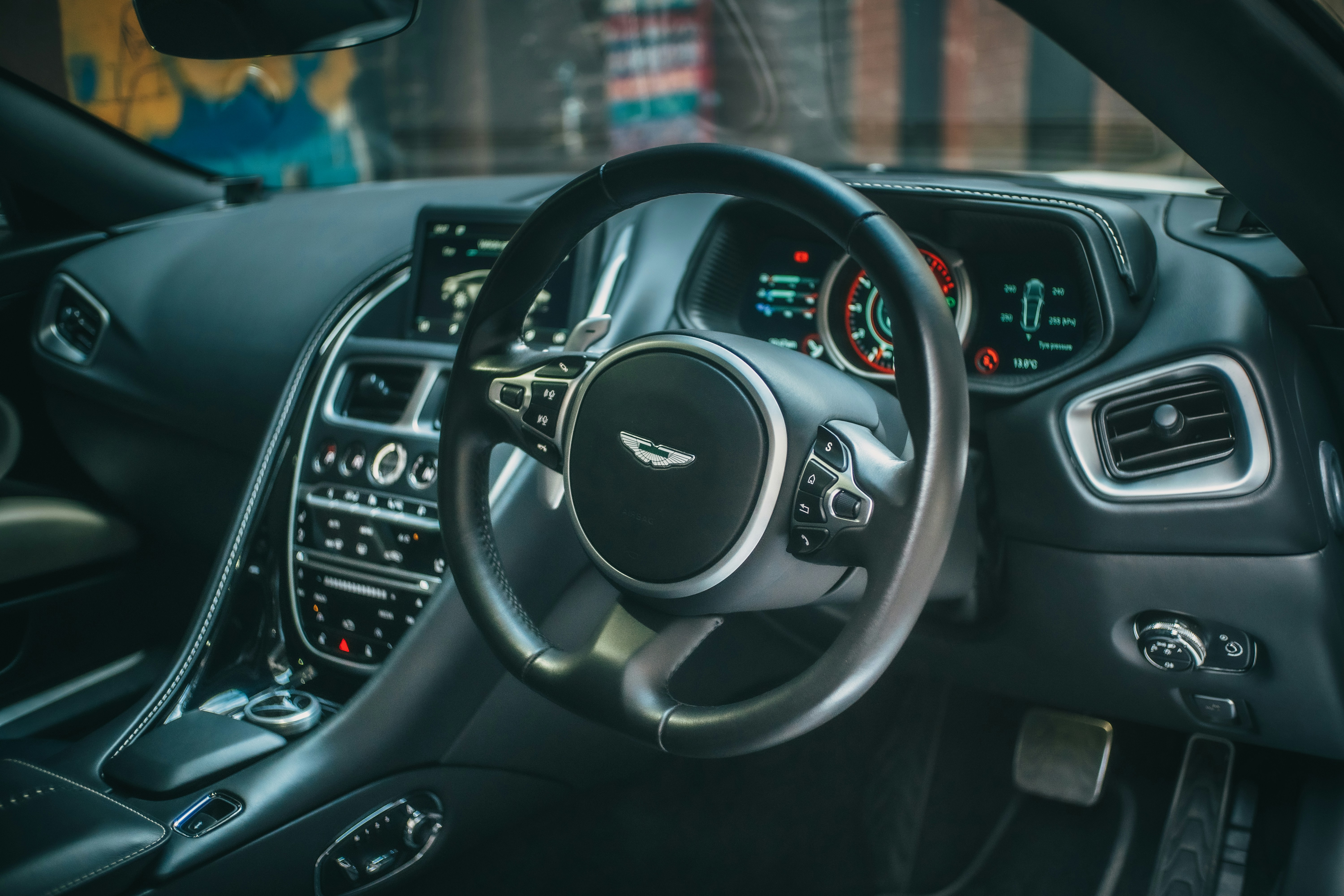 Intérieur de voiture de luxe Aston Martin avec volant et tableau de bord.