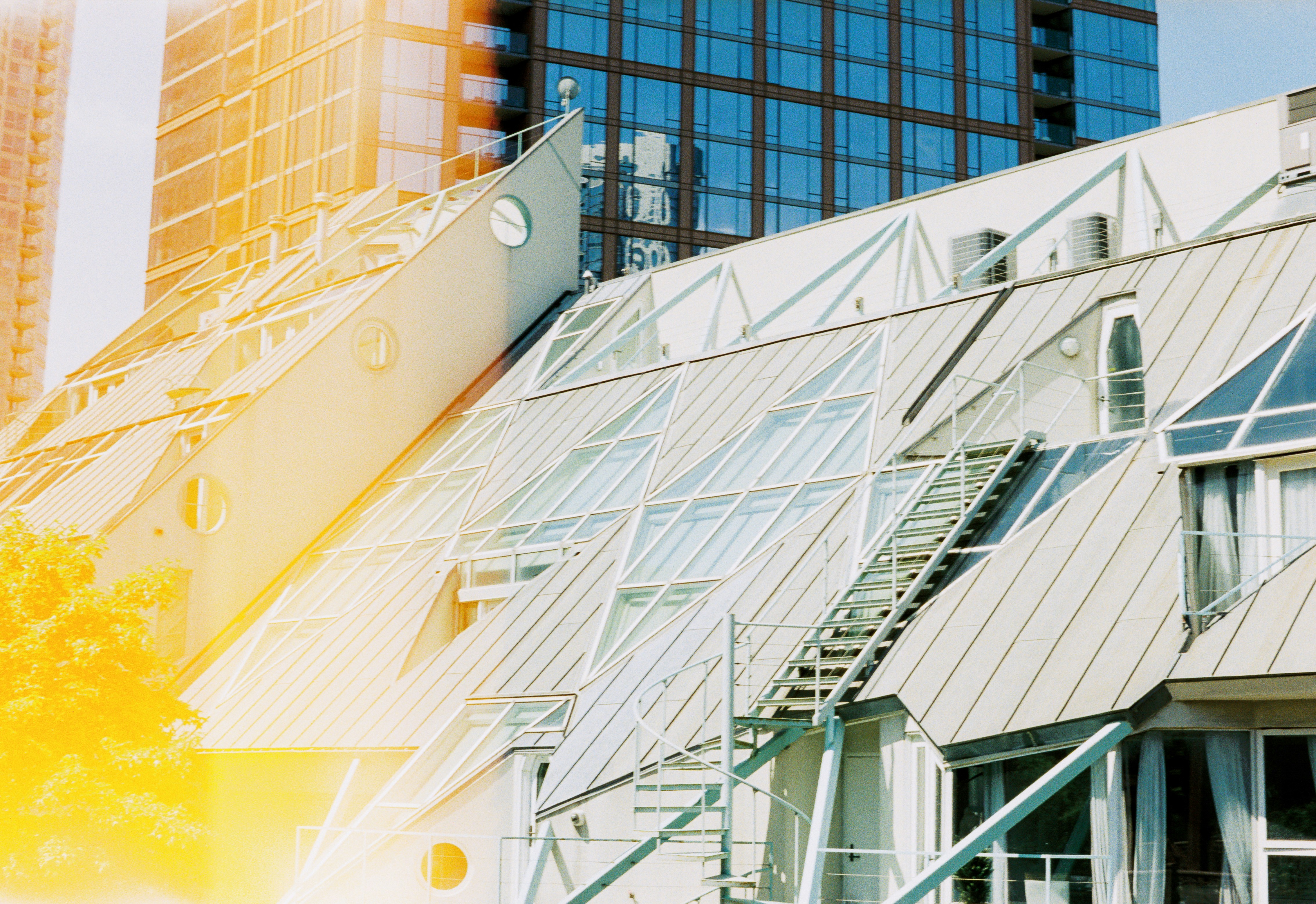 Modern building with angled glass roof and sun flare.