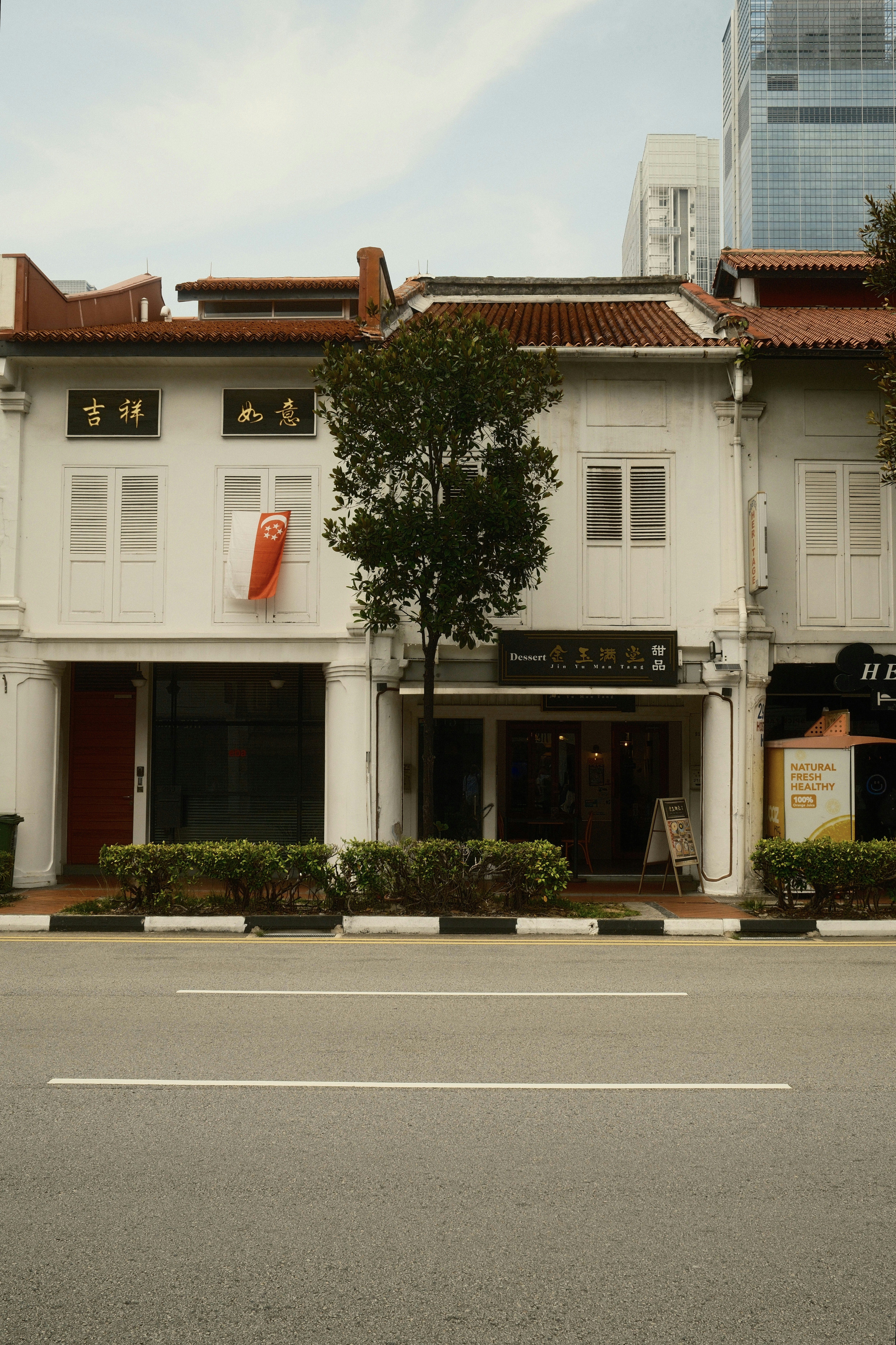 Traditional white buildings with red roofs line a street.