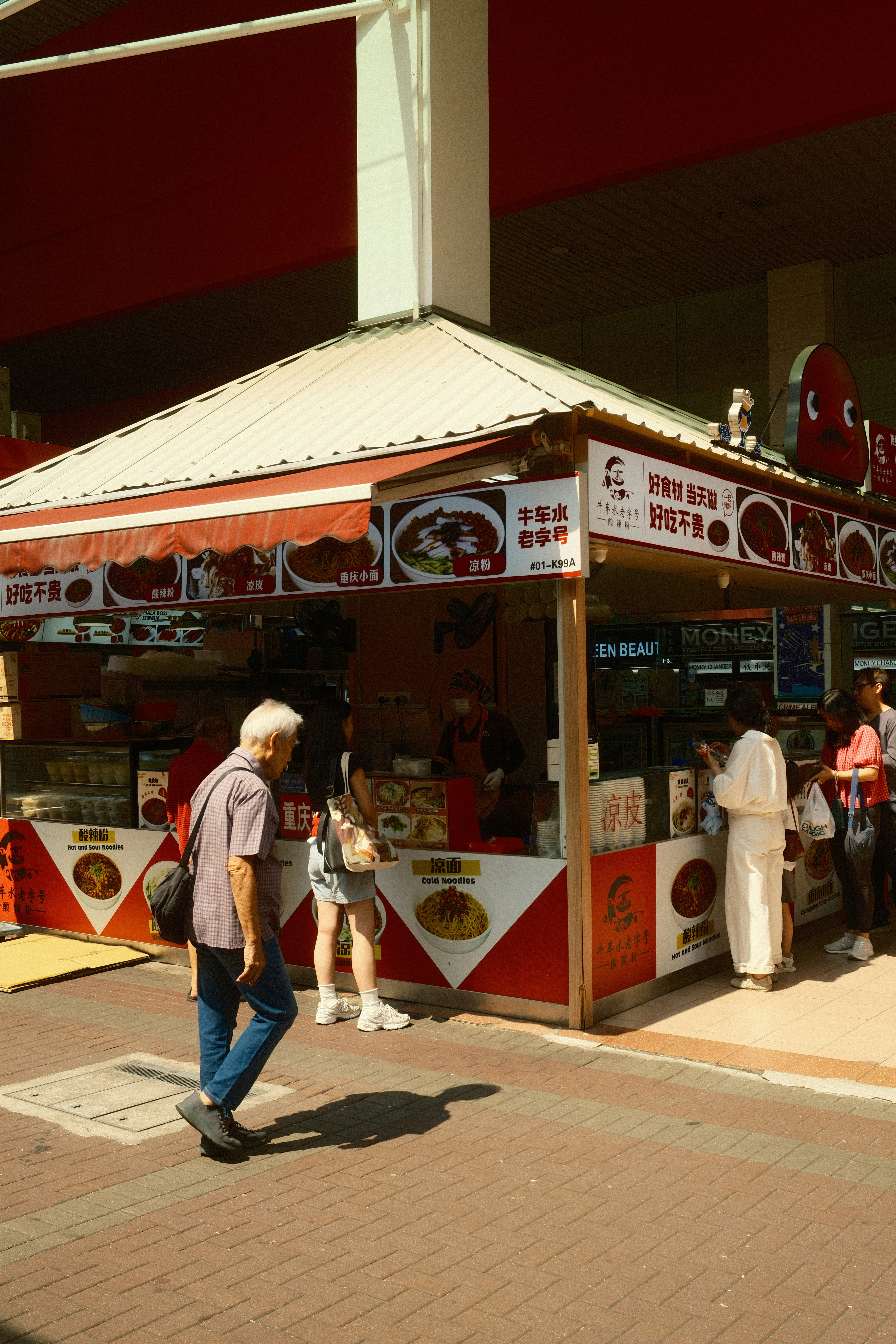 People gather at an outdoor food stall.
