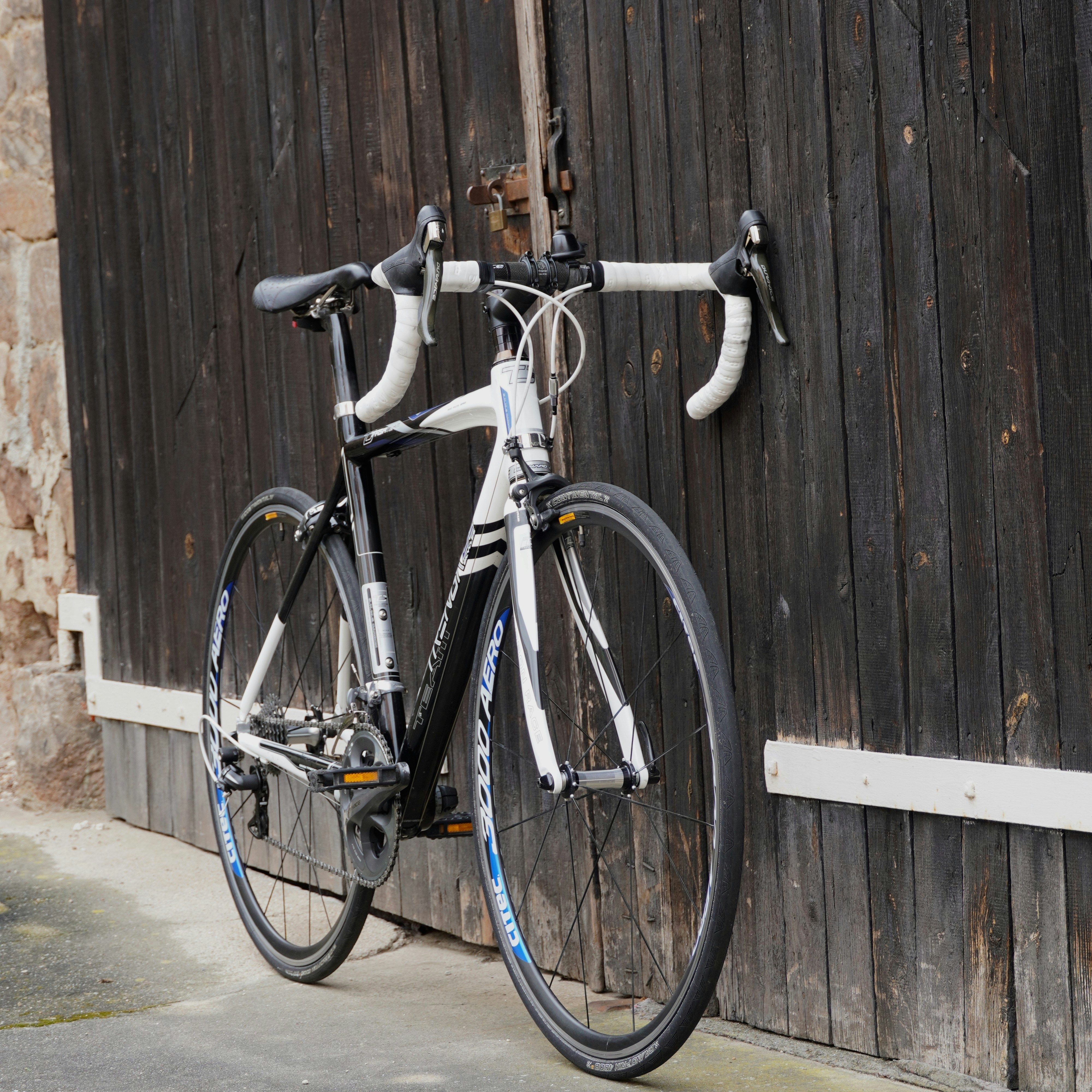 Road bicycle parked against a dark wooden door