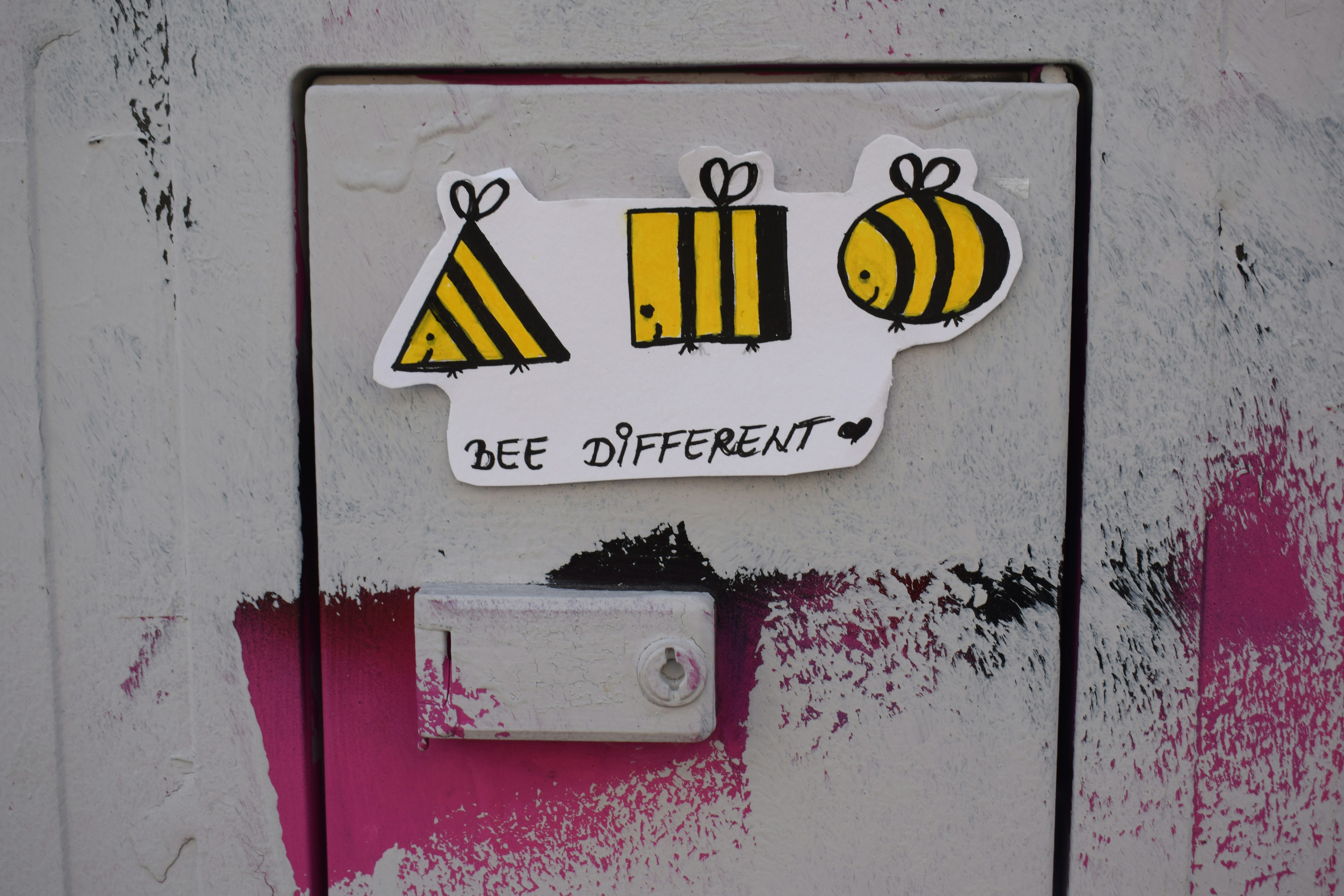 A sticker with three bee-themed shapes and 'bee different' text