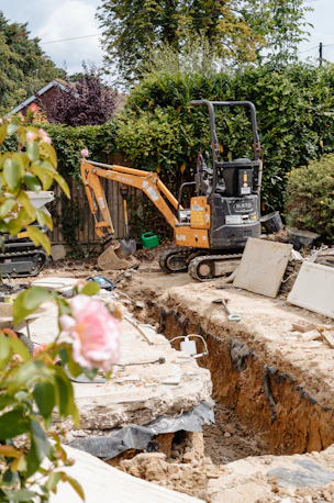 Mini excavator and trench in a backyard construction site