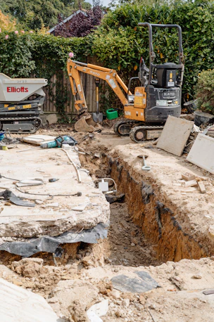 Mini excavator digging trench at construction site