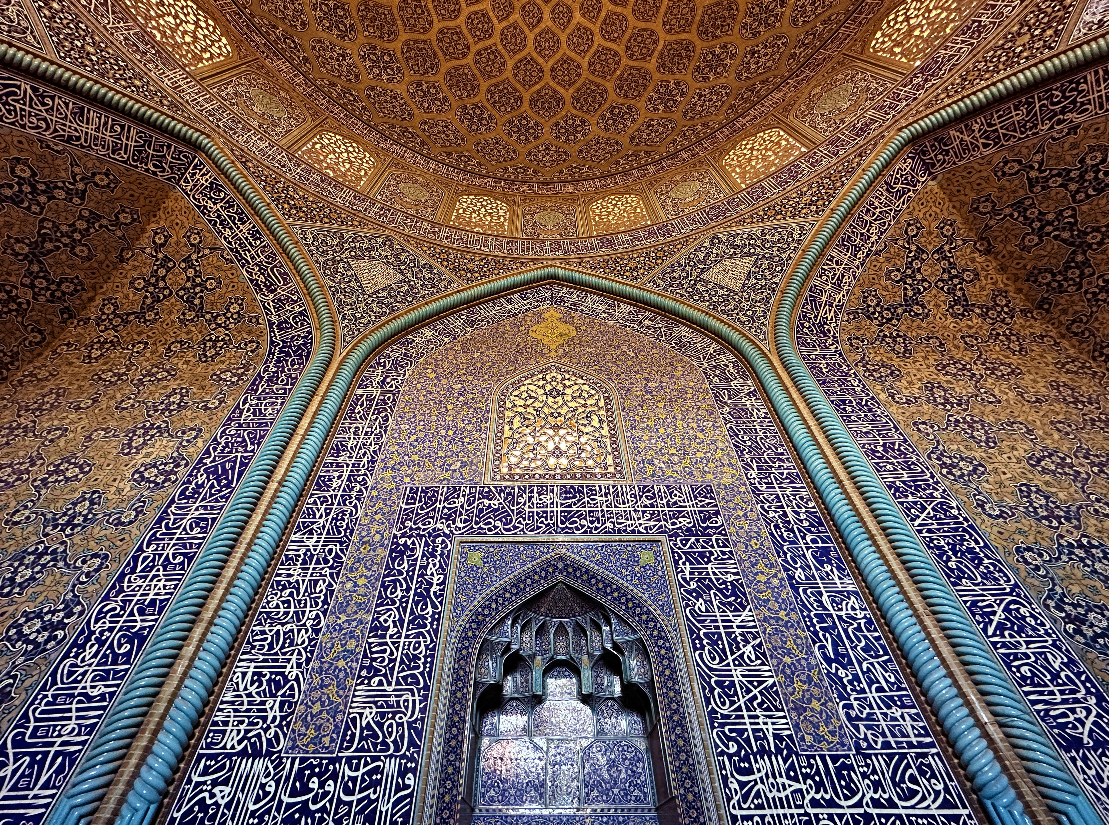 Intricate patterns adorn a mosque's dome and arched entrance.