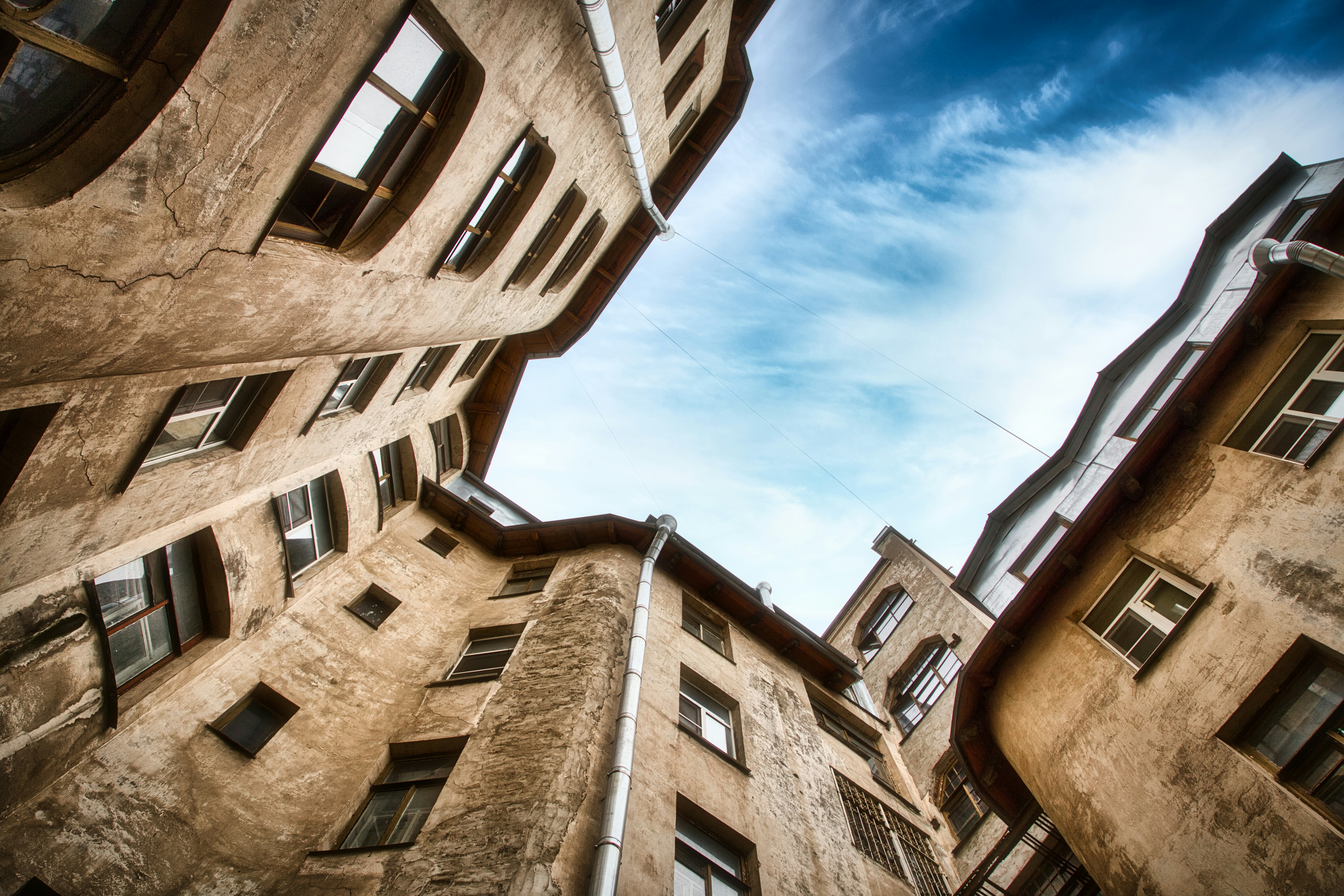 Old buildings towering over a cloudy blue sky.