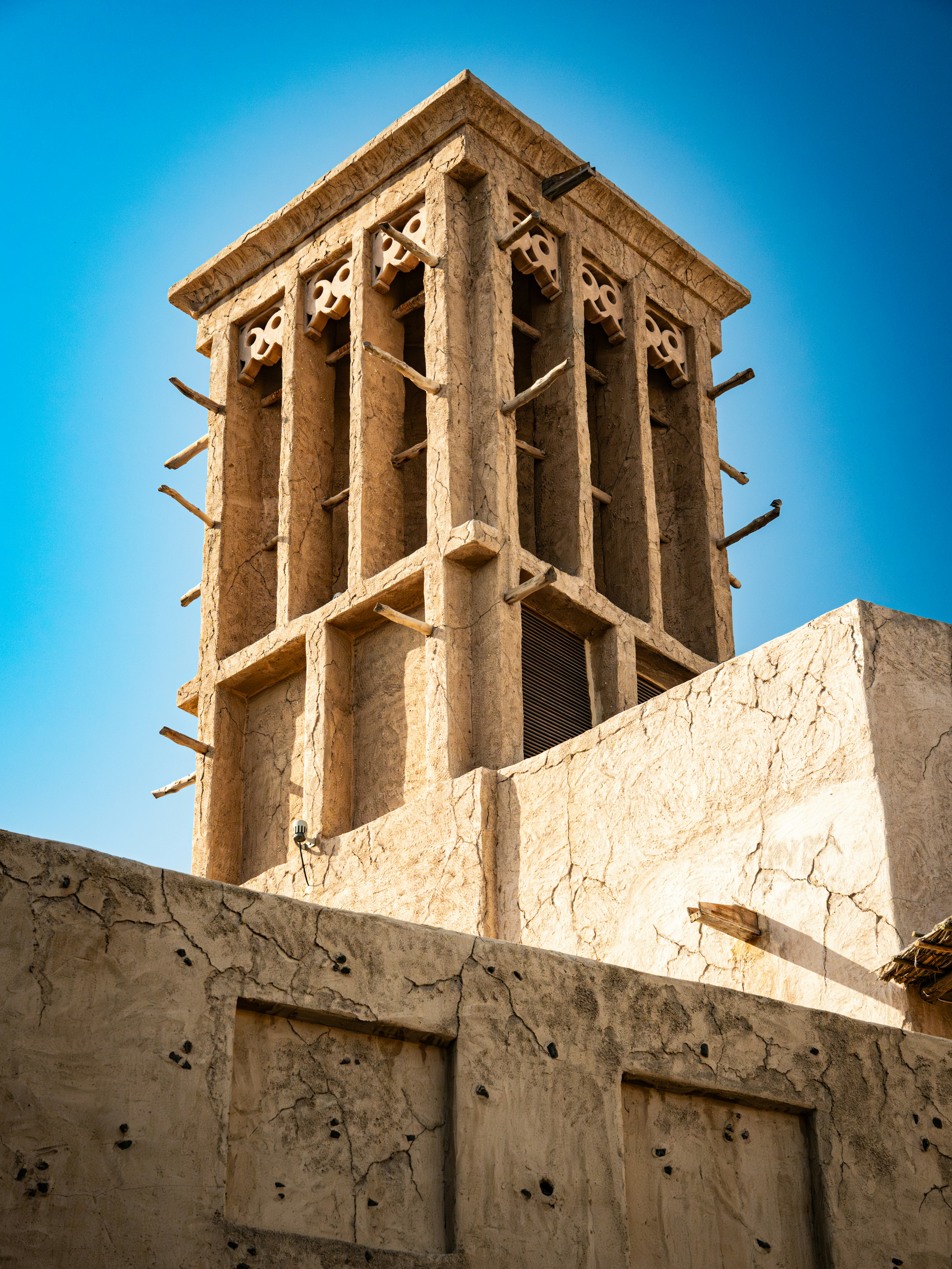 A traditional middle eastern wind tower against a blue sky