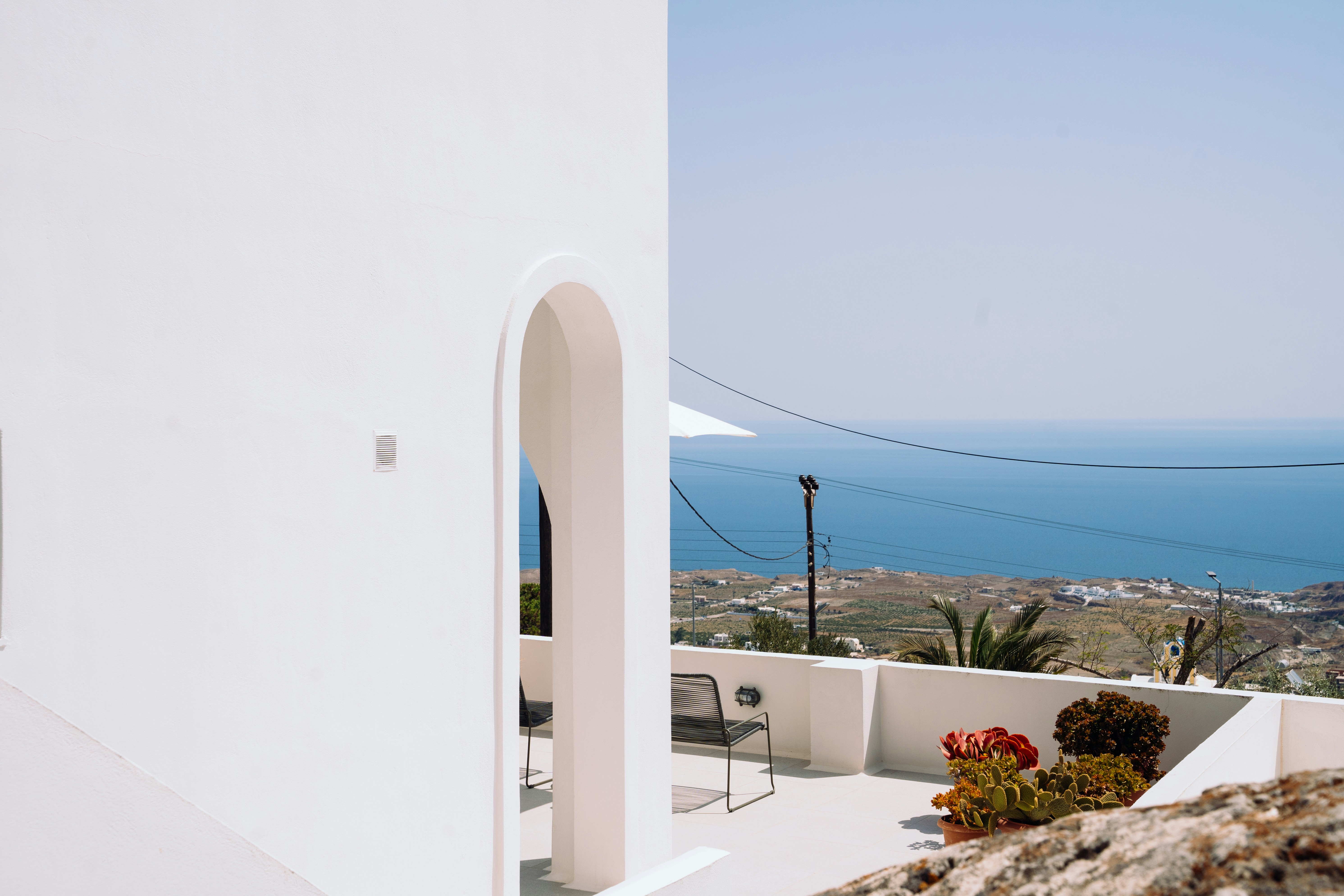Edificio minimalista blanco con entrada arqueada y vistas al mar