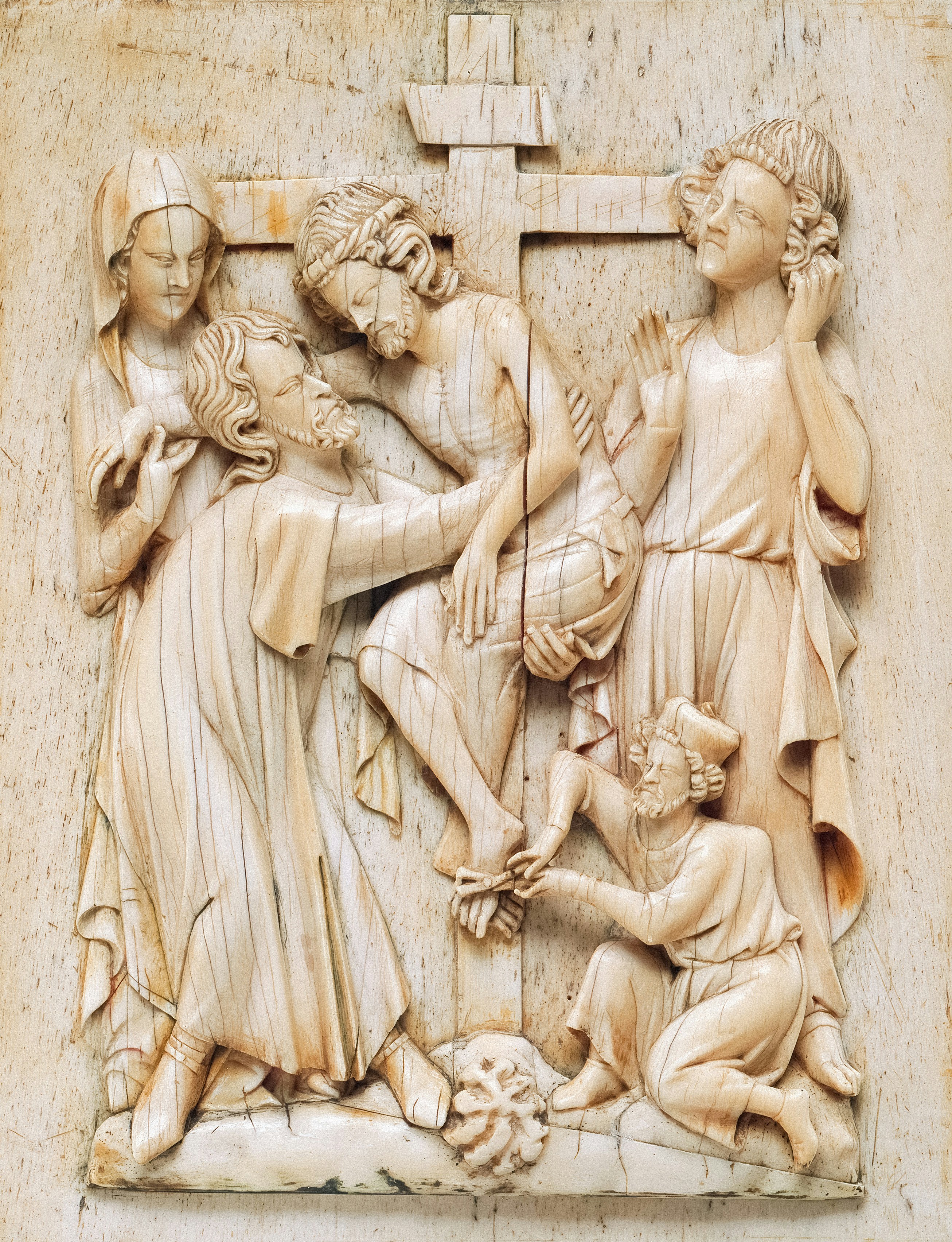 Ancient ivory carving depicts jesus being taken down from cross.