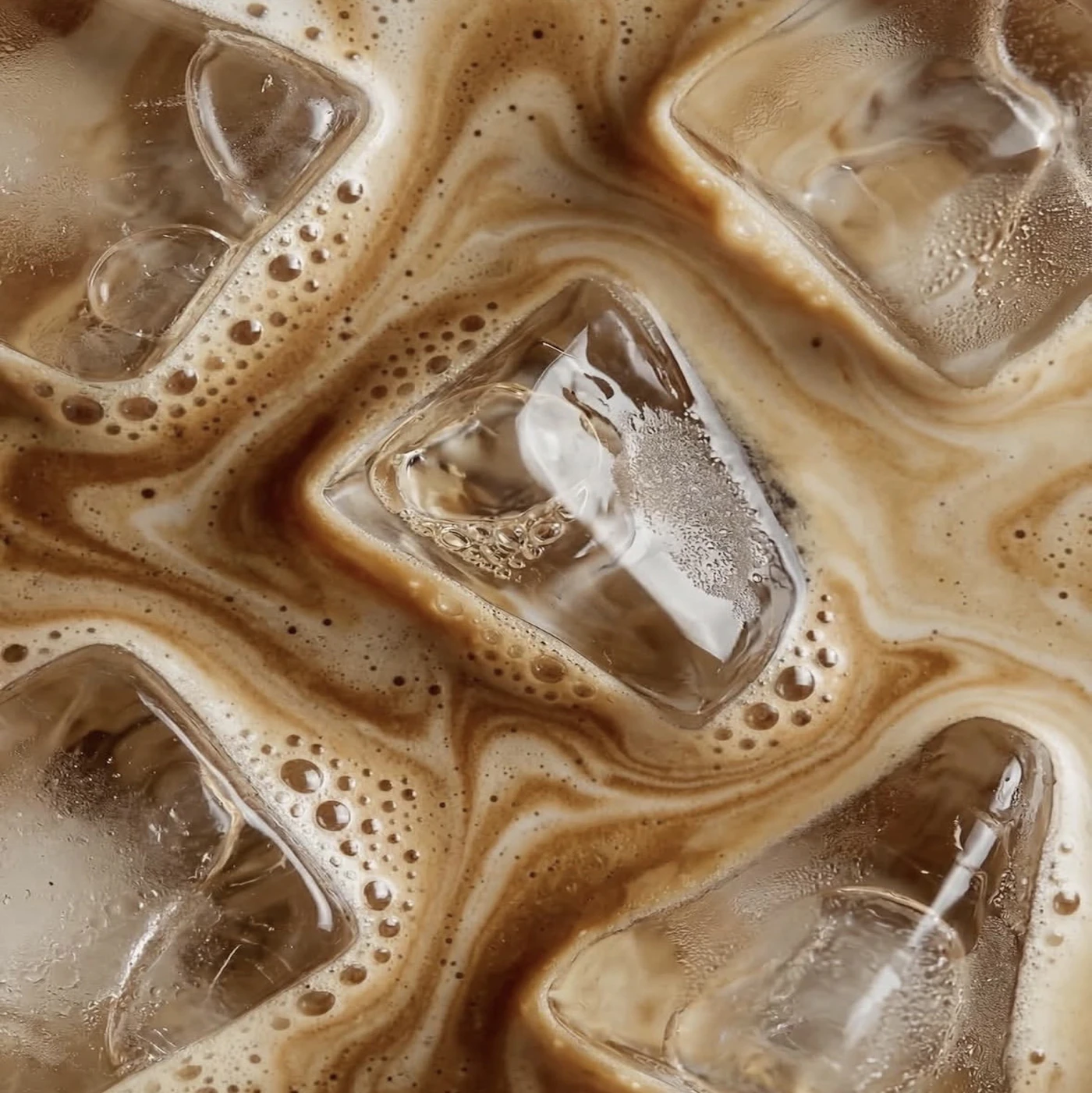 Close-up texture of creamy iced coffee and ice cubes
