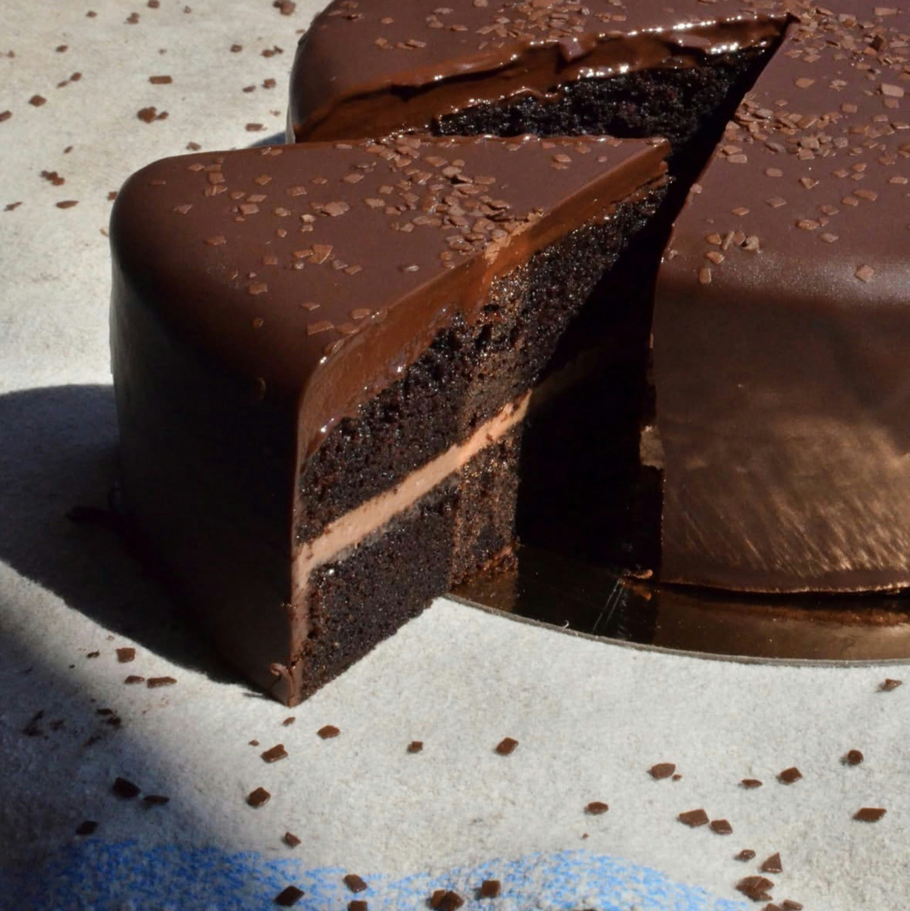 Decadent chocolate cake with a slice cut out and sprinkles