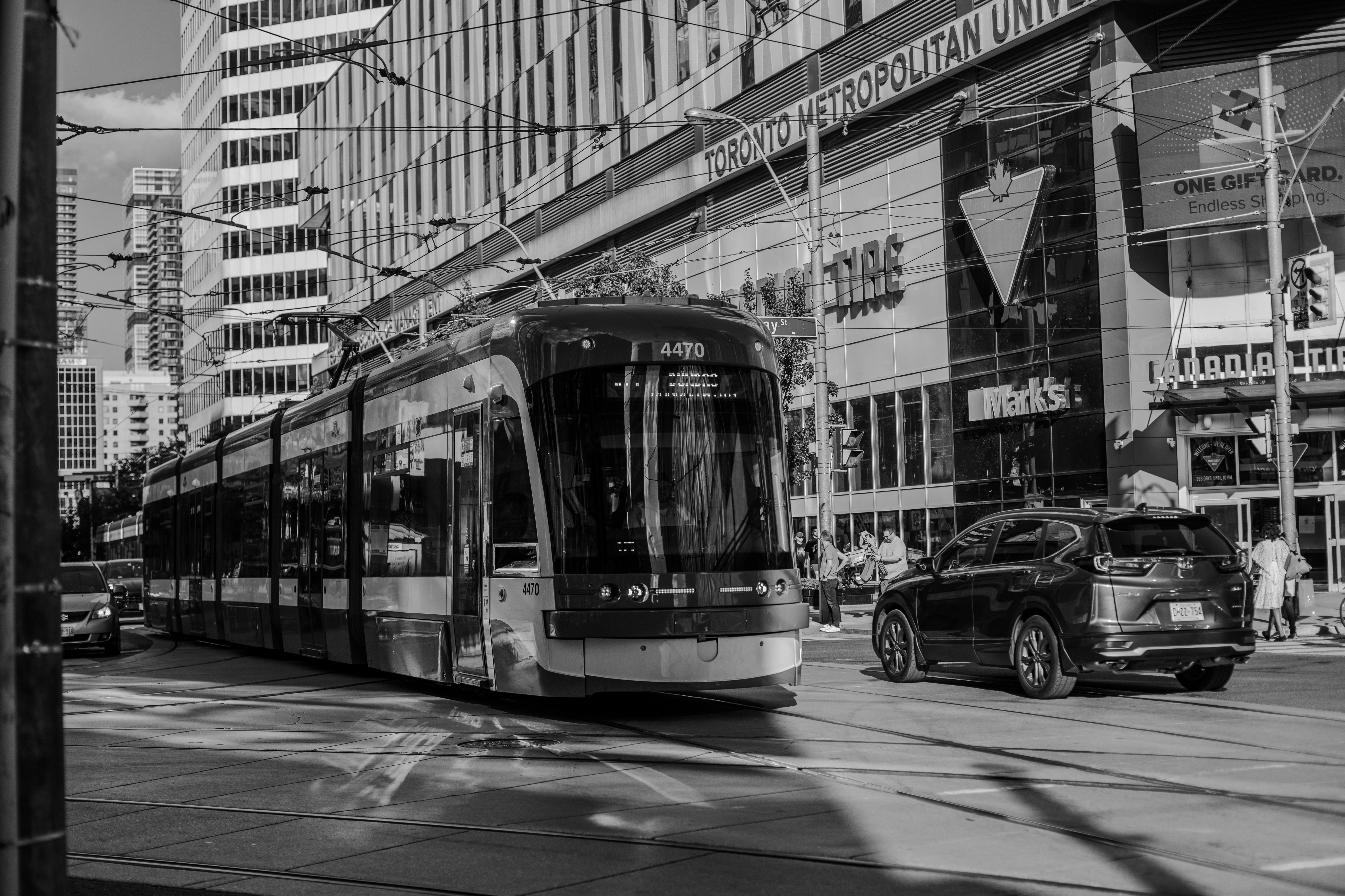 Black and white photo of a modern tram on a city street