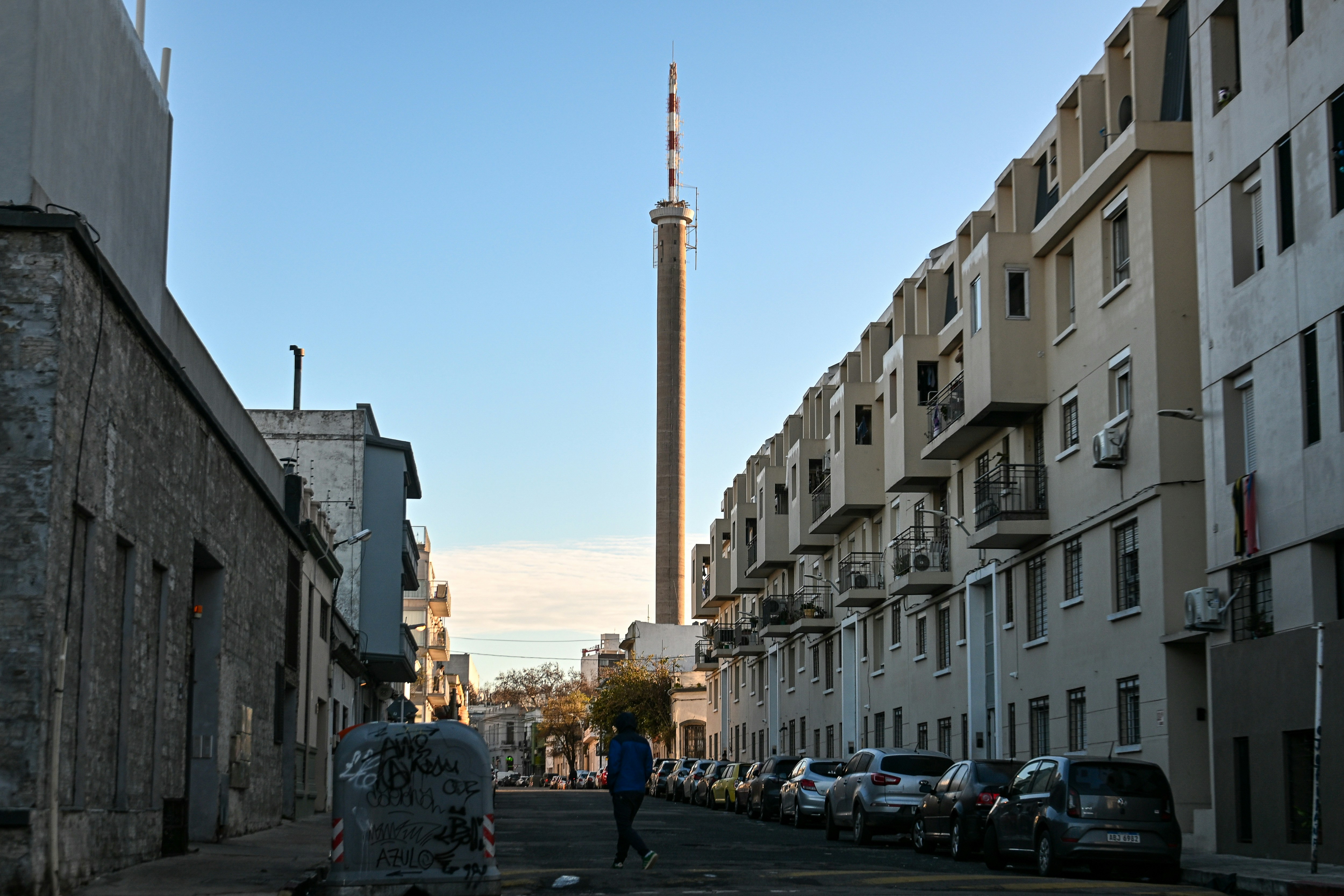 Urban street with buildings and a tall tower.