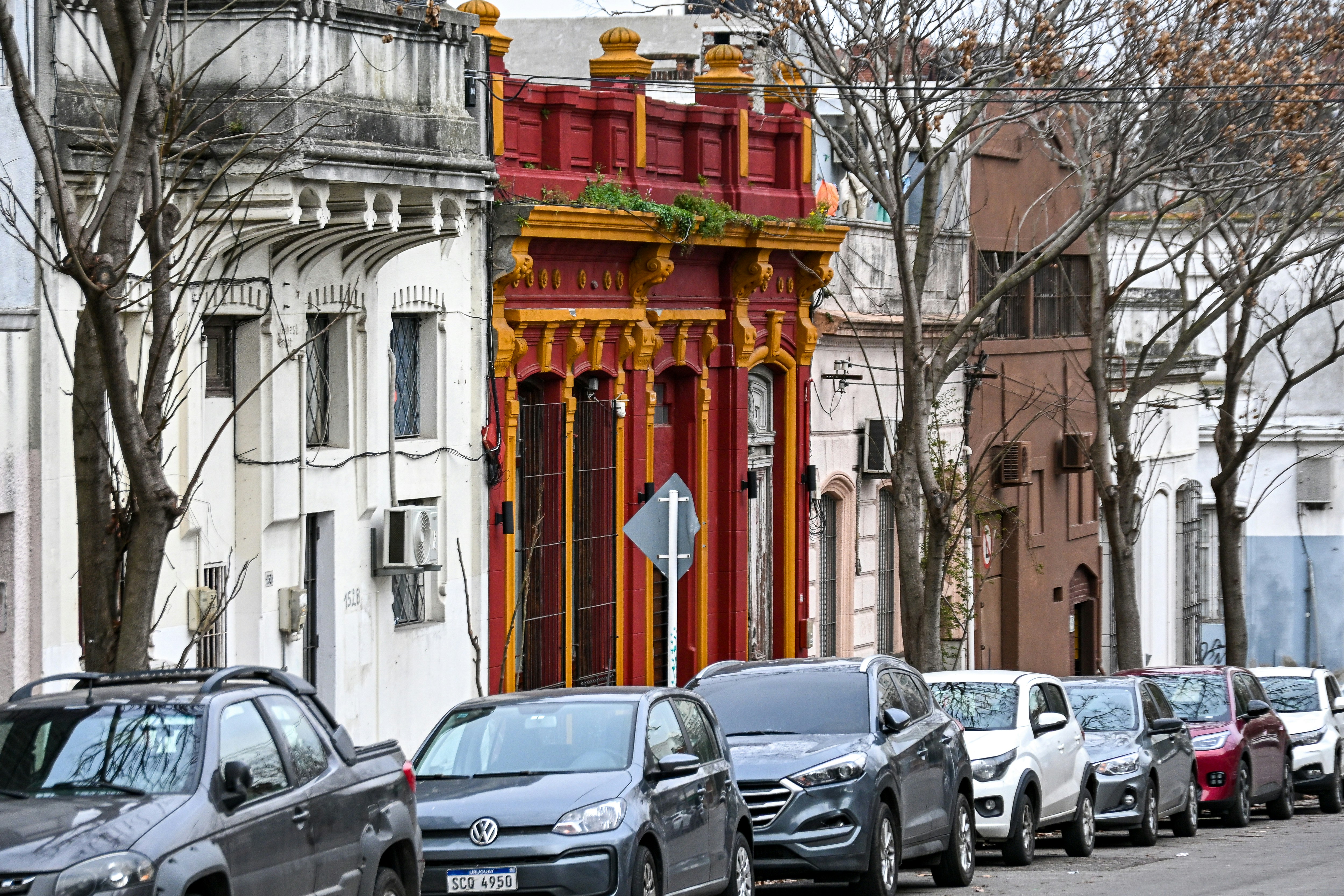 Parked cars line a street with colorful historic buildings.