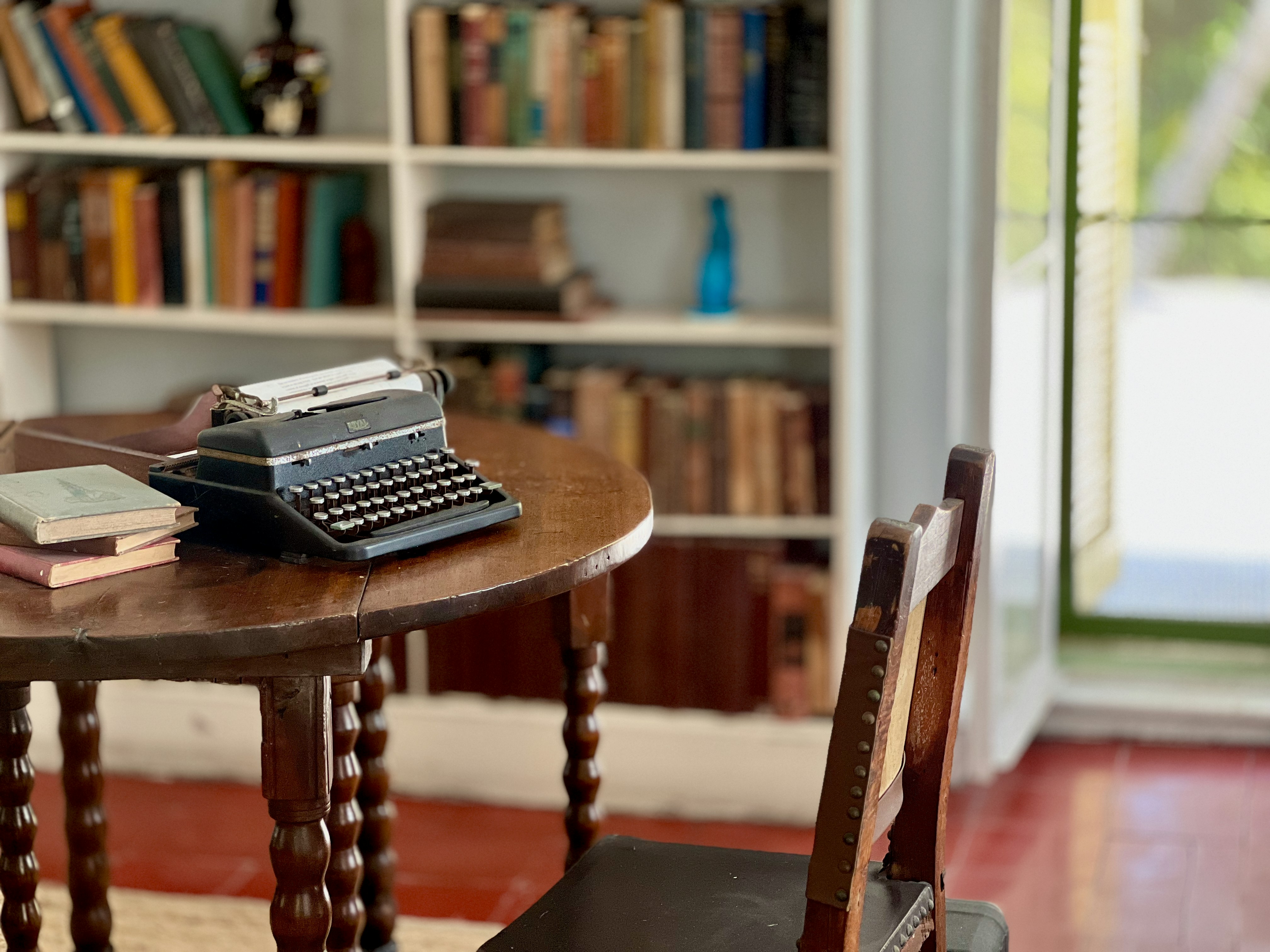 Macchina da scrivere vintage su tavolino di legno con libri e libreria