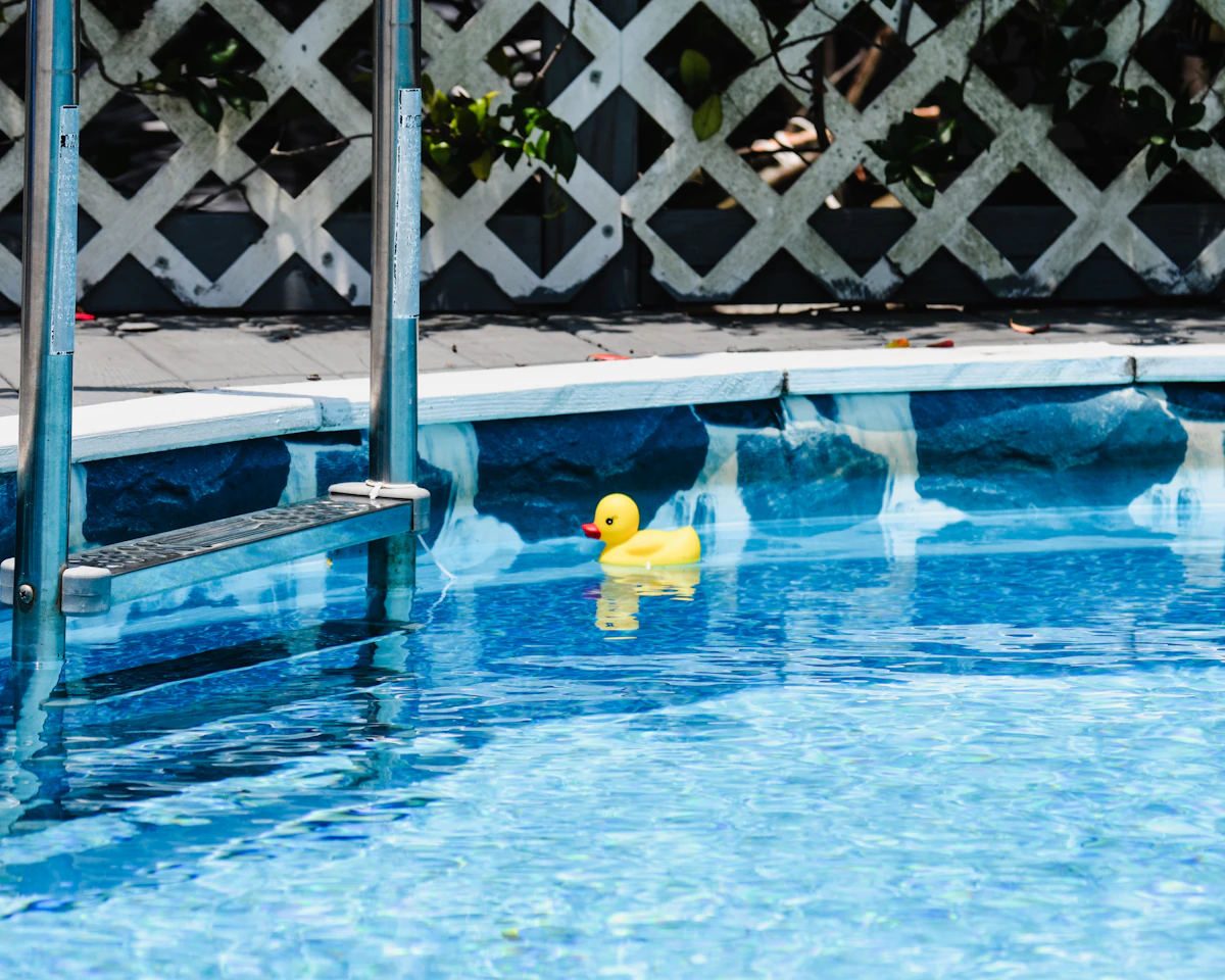 Gelbe Quietscheente im blauen Pool
