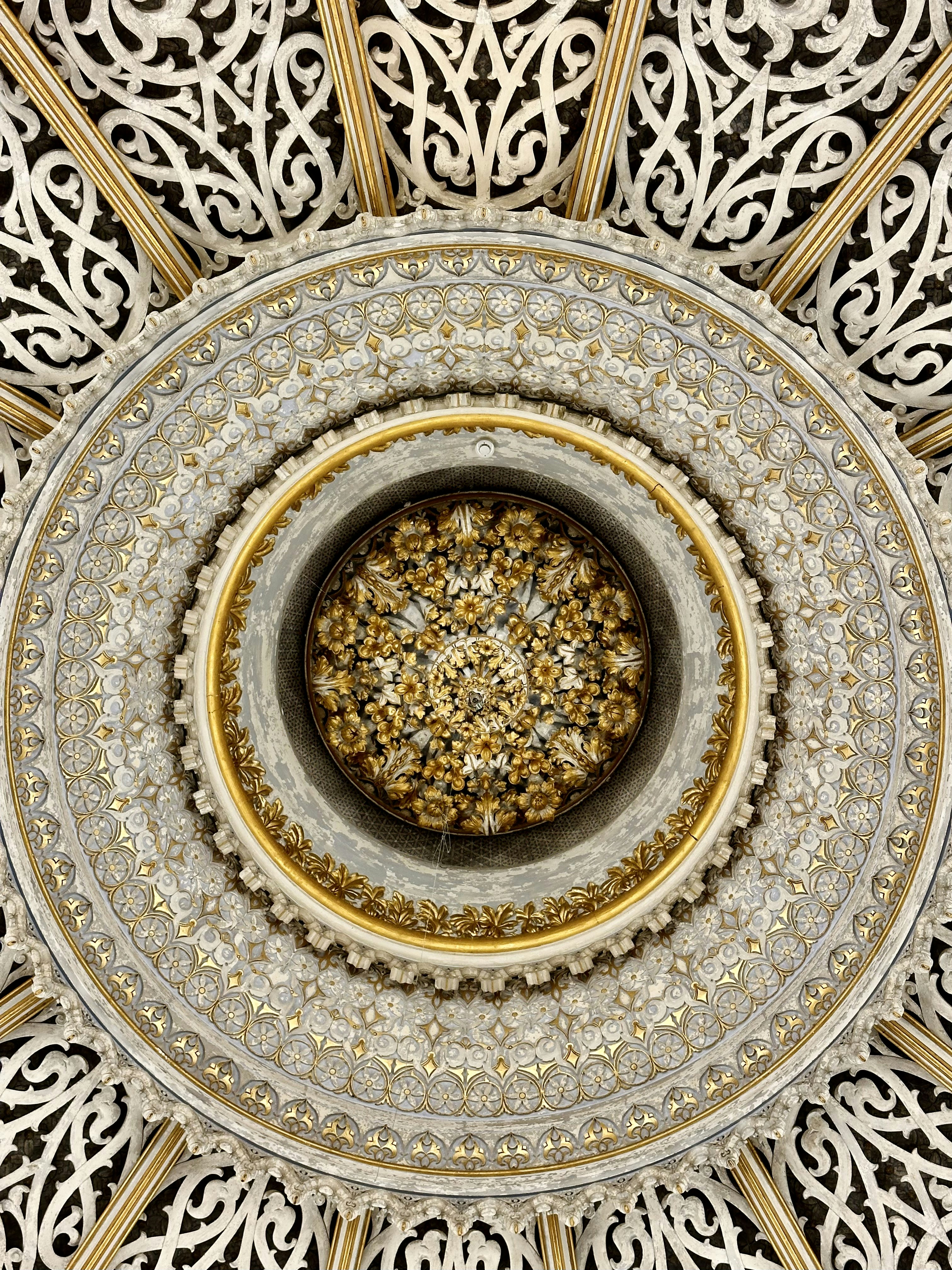 Techo circular ornamentado con intrincados patrones blancos y dorados
