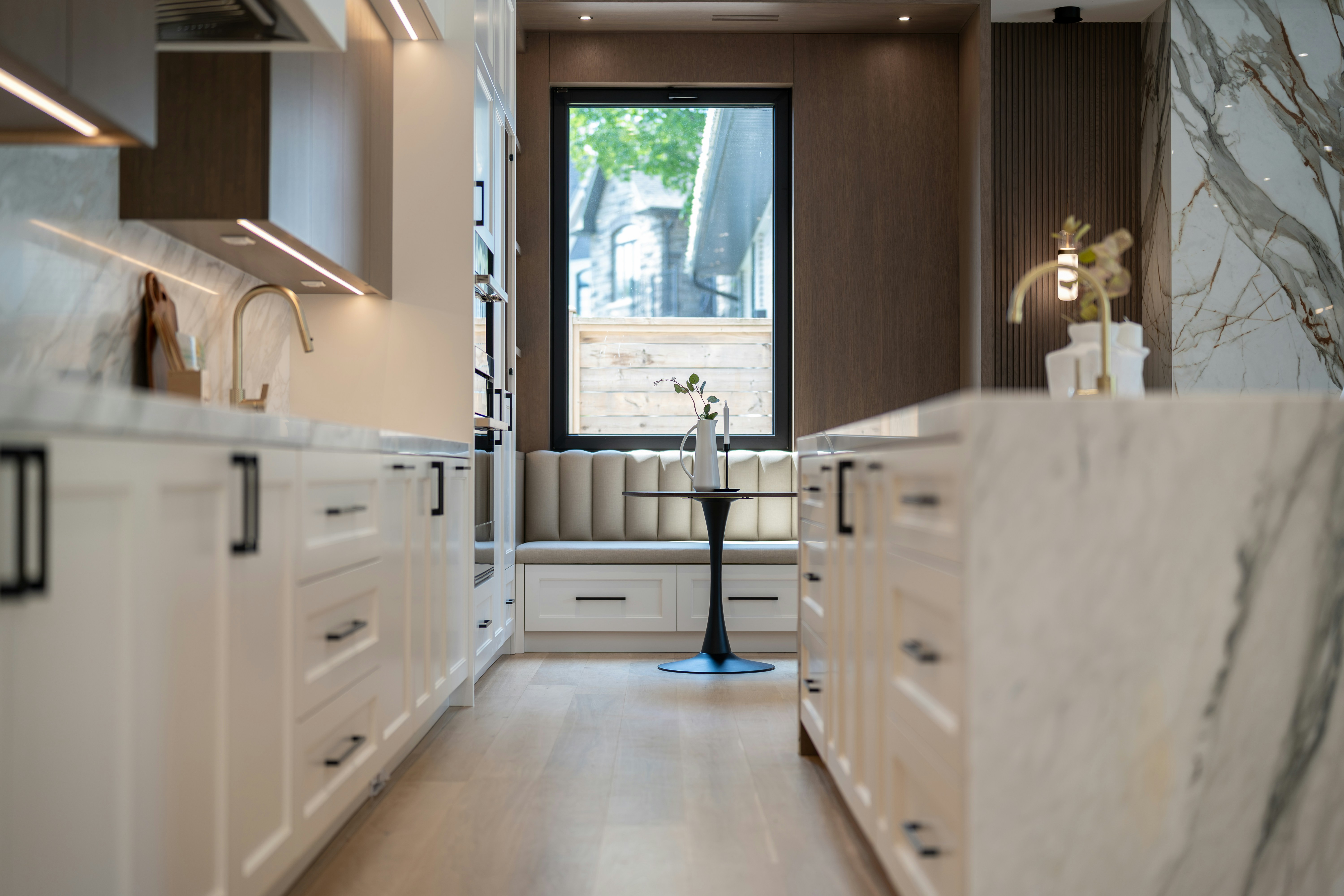 Elegant modern kitchen with white cabinets and marble countertops.