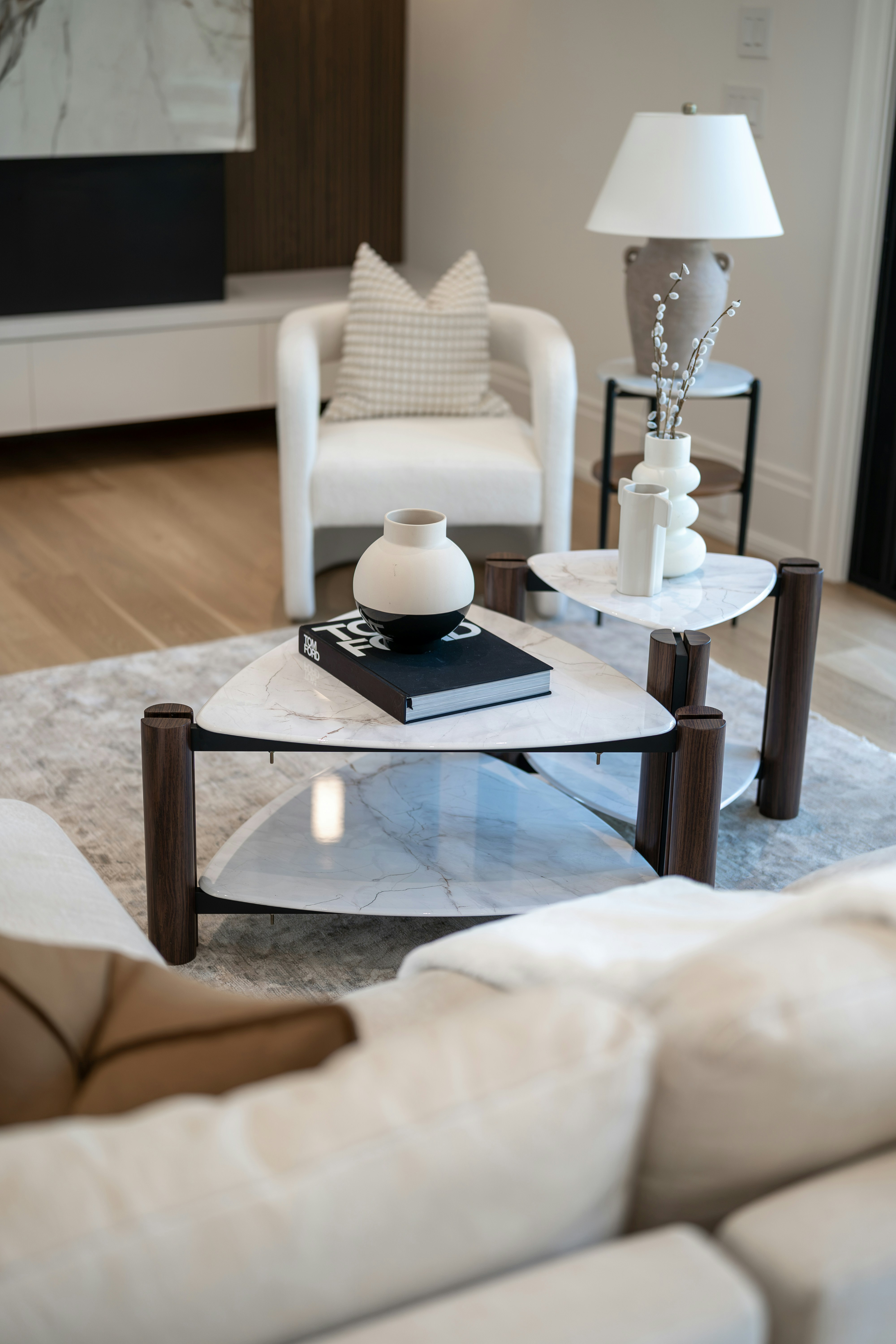 A stylish living room with a unique triangular coffee table.