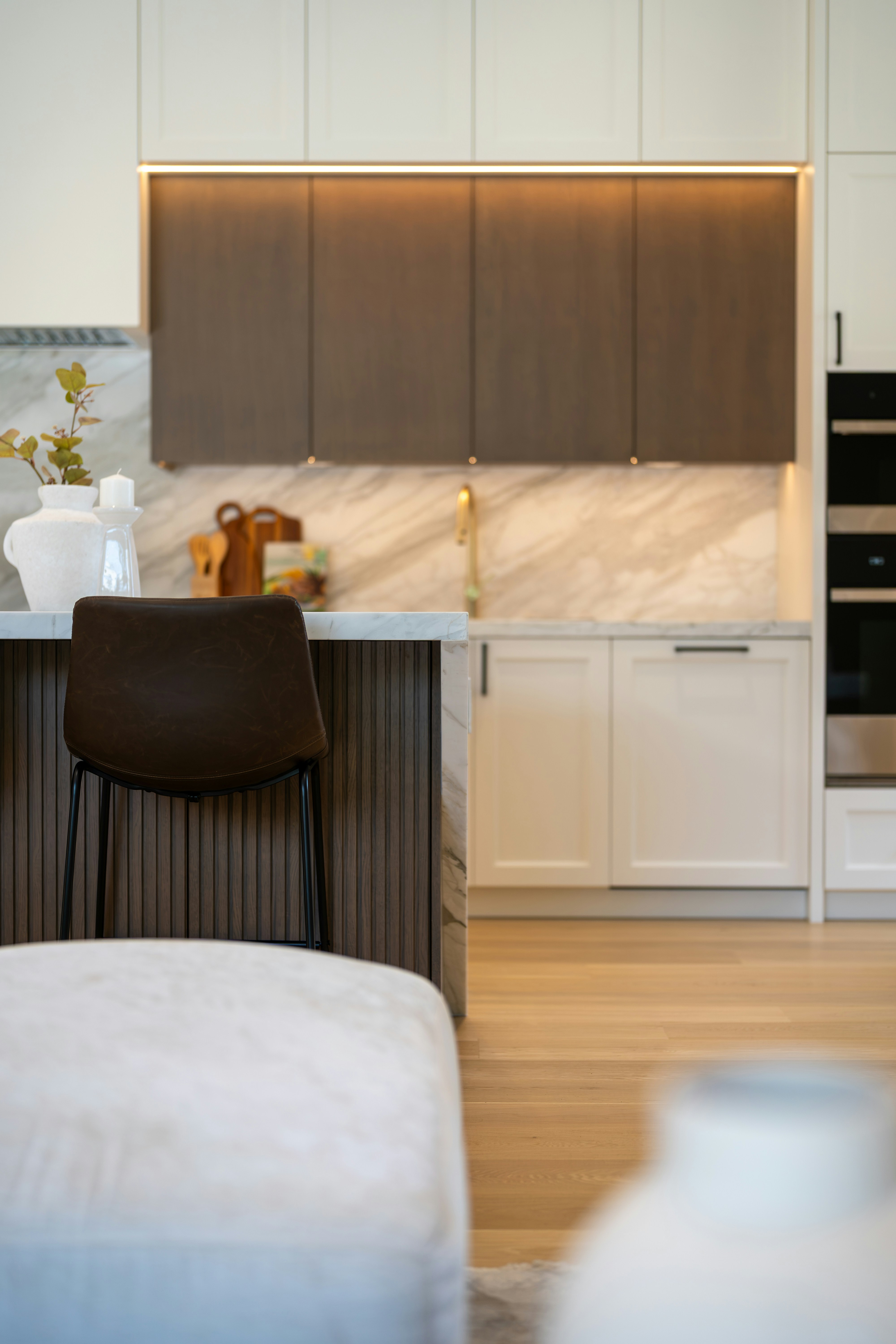 Modern kitchen interior with island, bar stool, and elegant cabinetry.