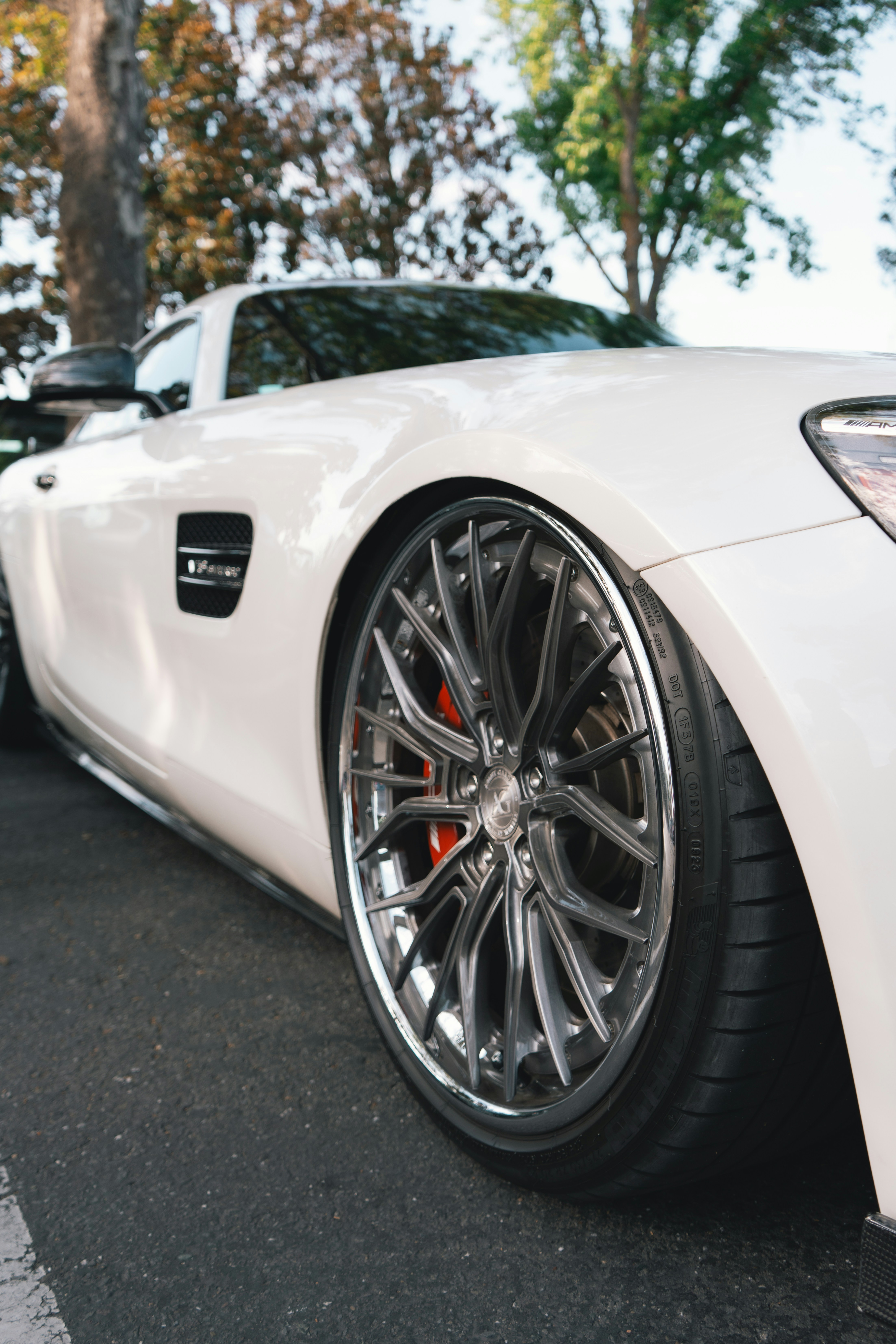 Carro de luxo branco com rodas polidas sob medida e freios vermelhos