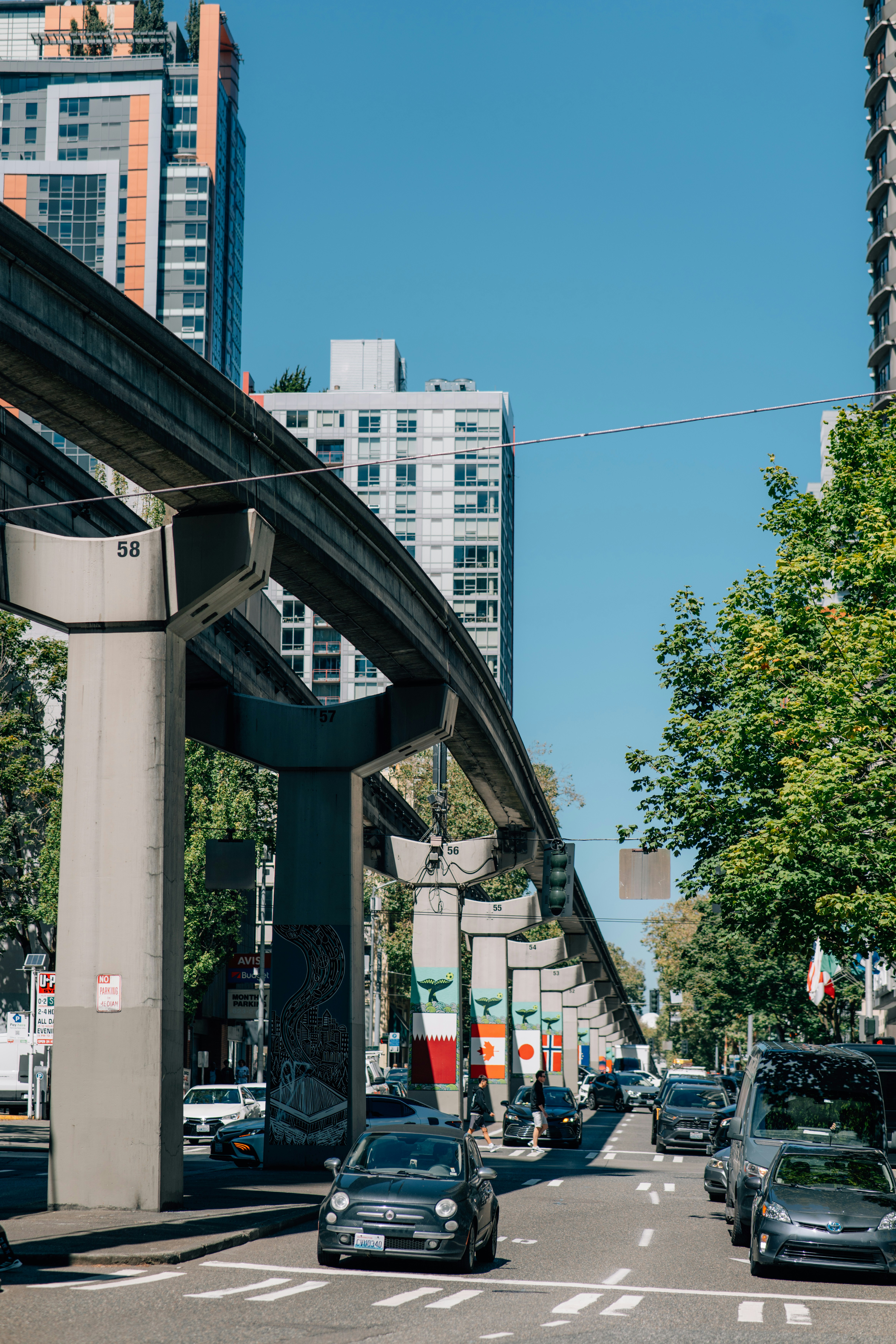 Monorail track above a city street with cars and buildings