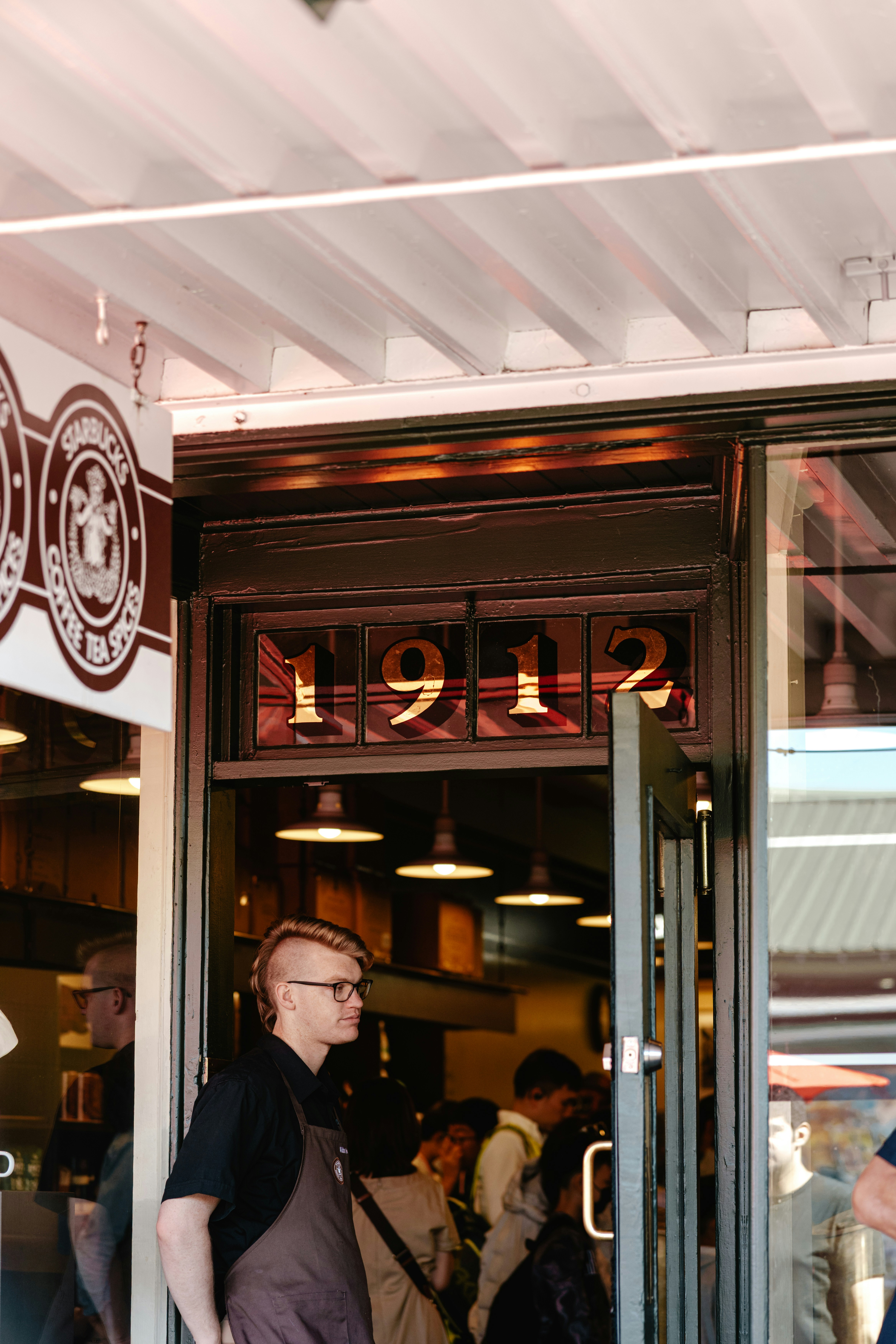 A person stands at a building entrance marked "1912"