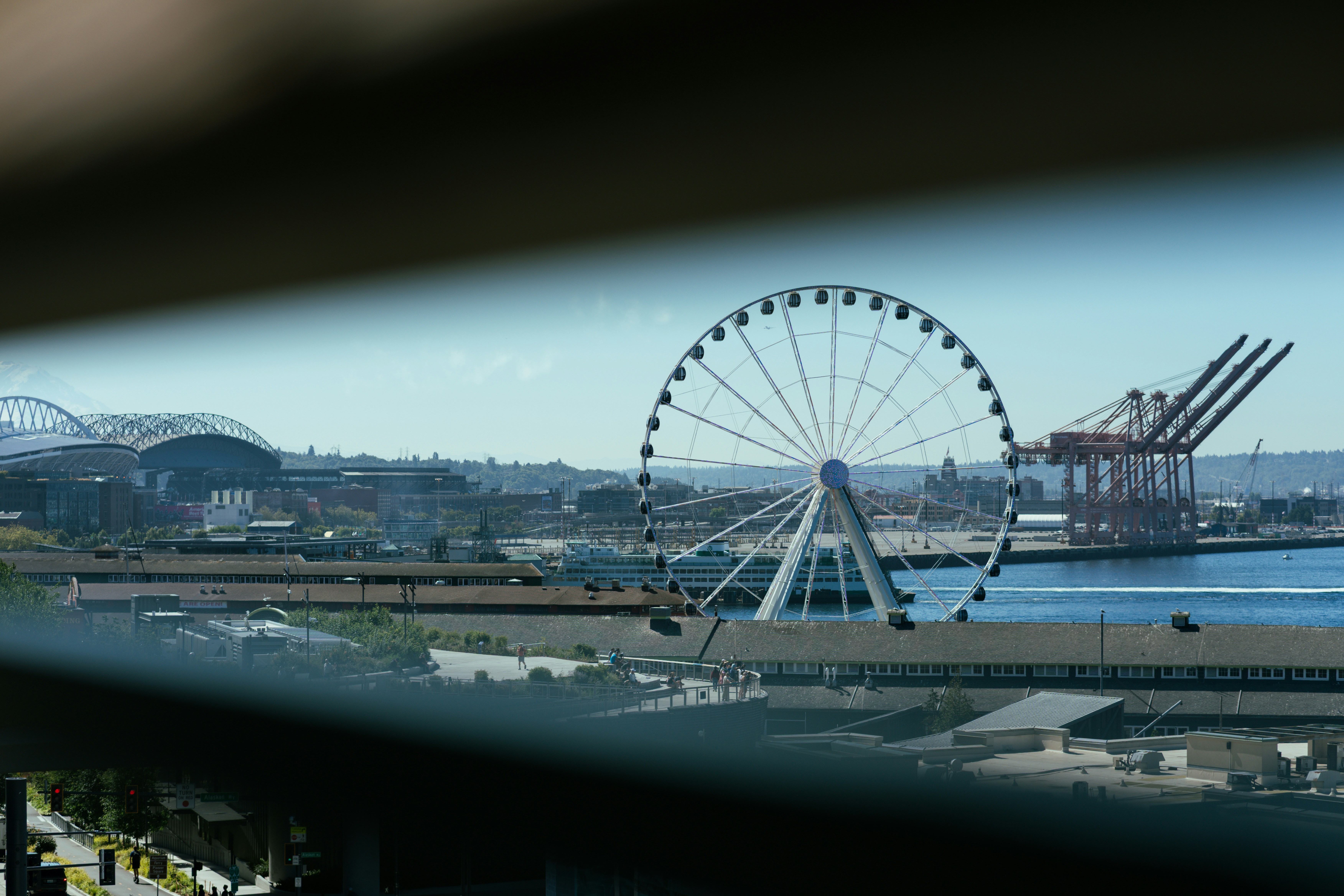 A large ferris wheel overlooks a bustling port