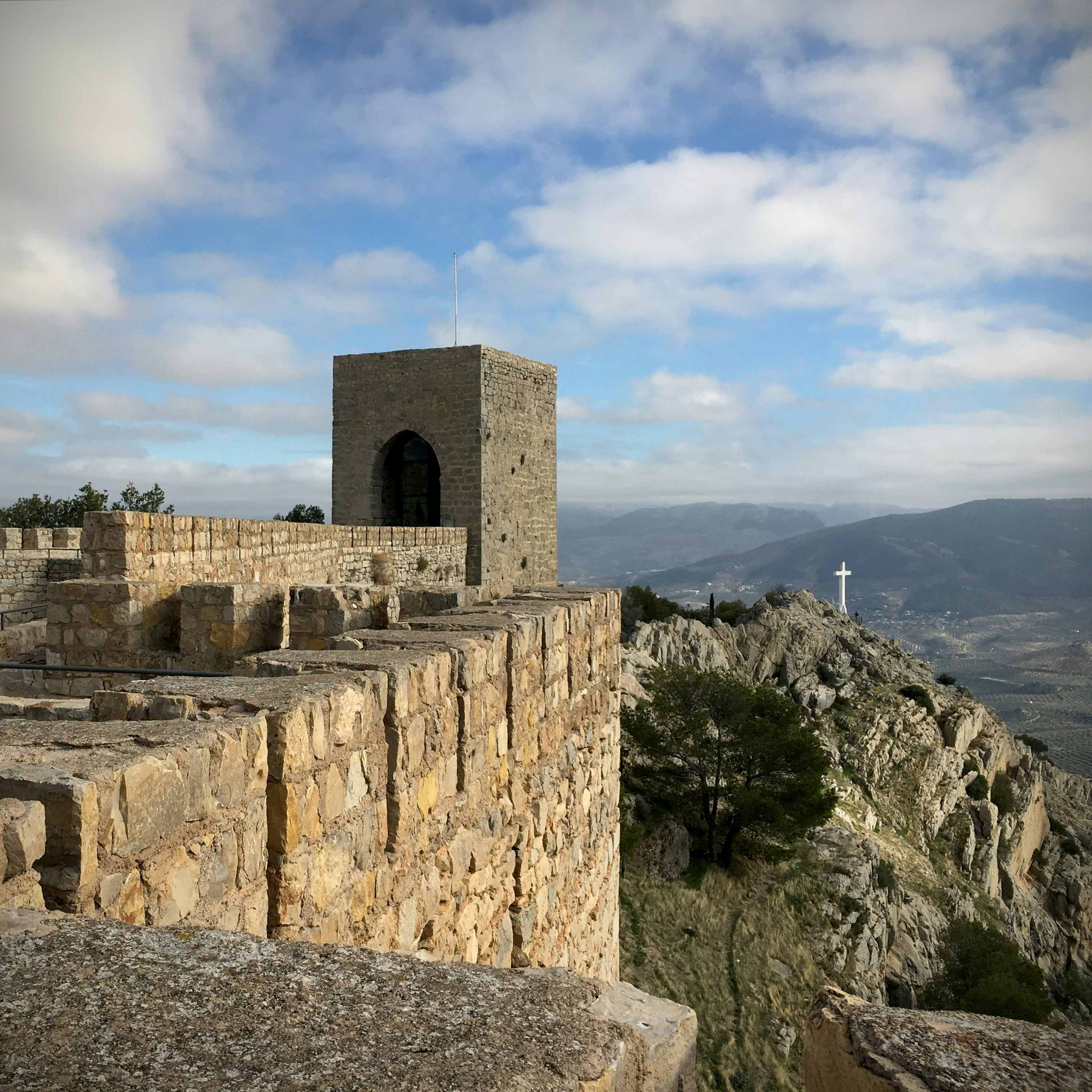 Ancient stone fortress walls overlooking a vast mountainous landscape