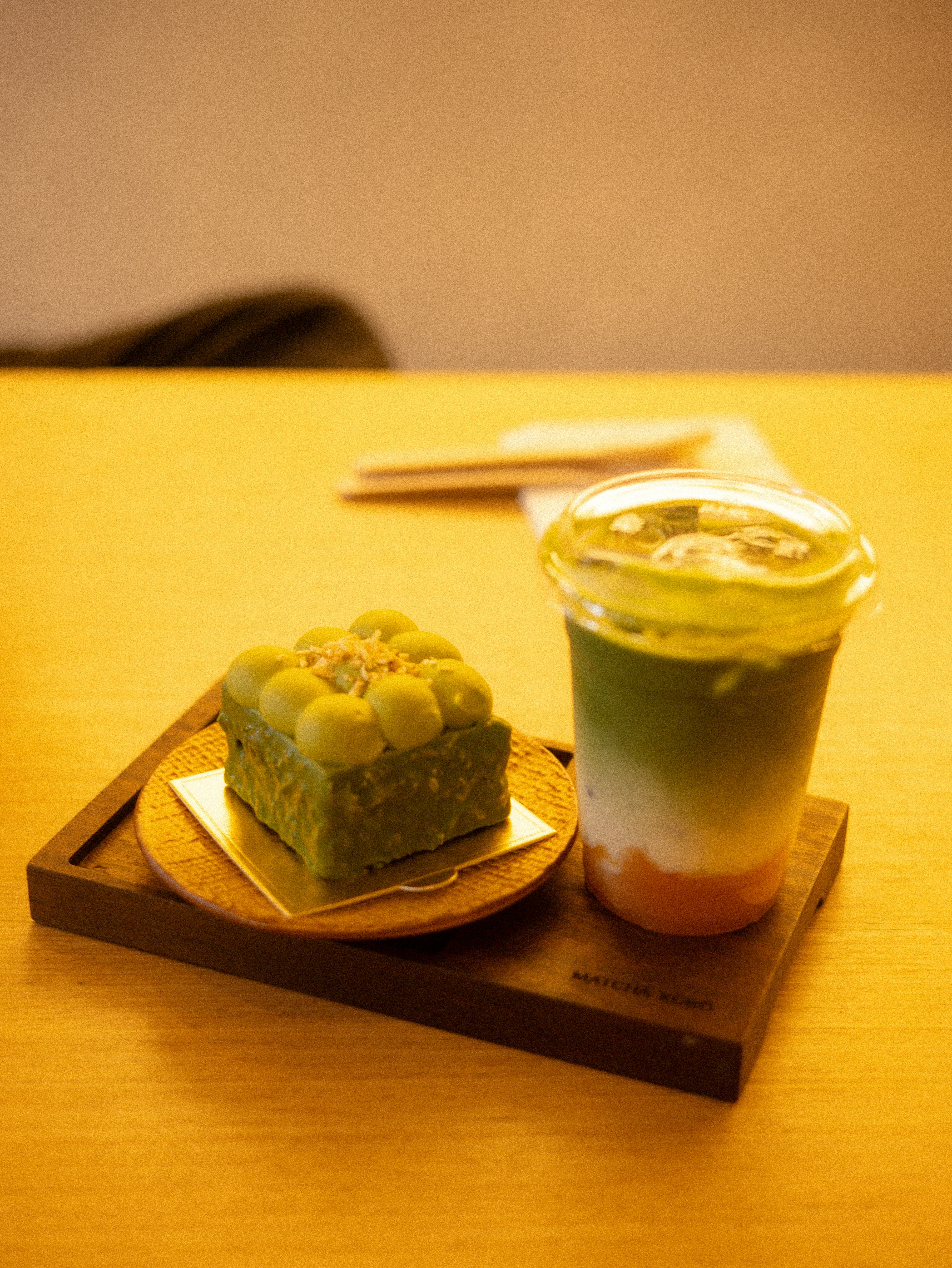 Green matcha cake and layered drink on a wooden table