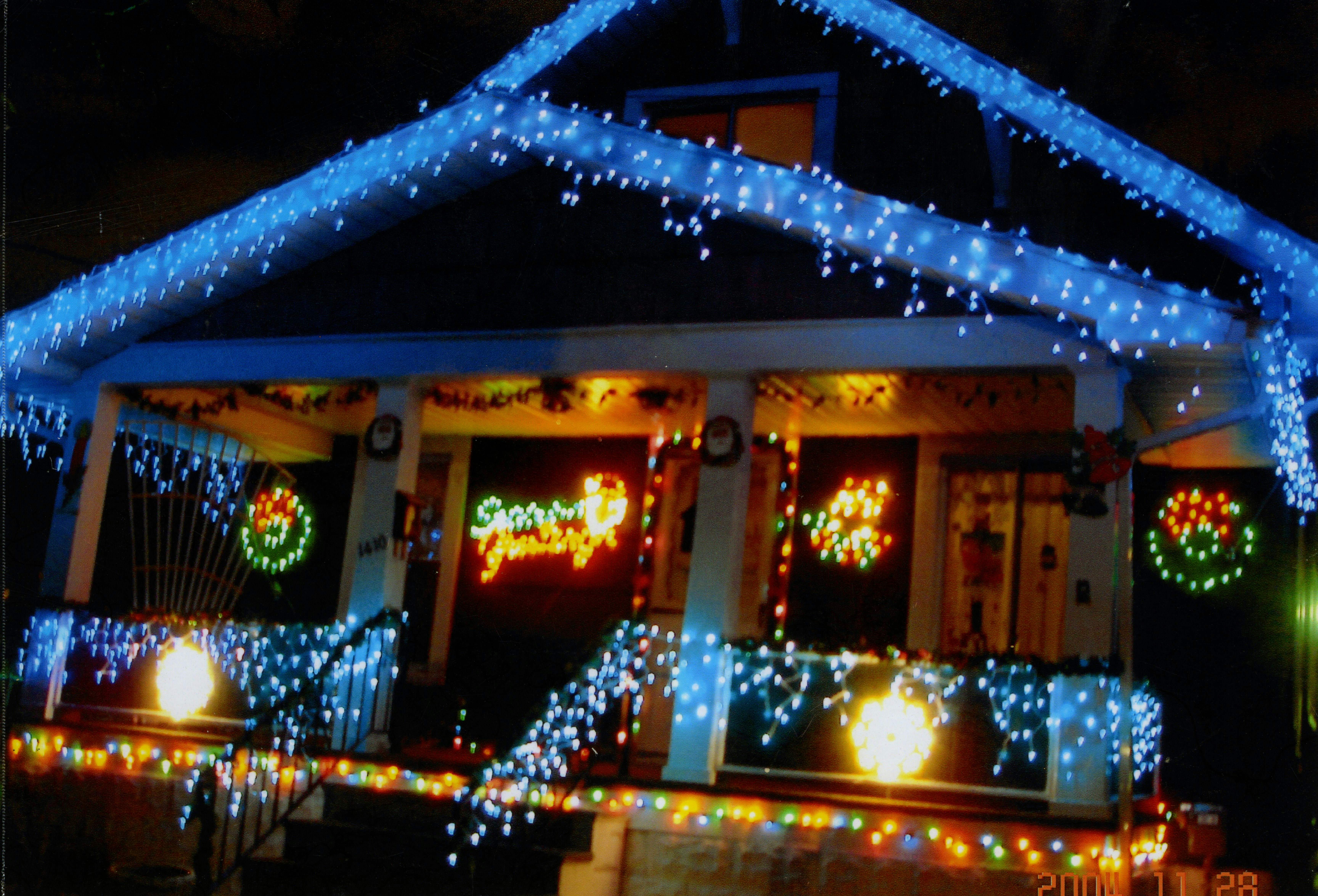 House brightly decorated with blue and multicolored christmas lights.