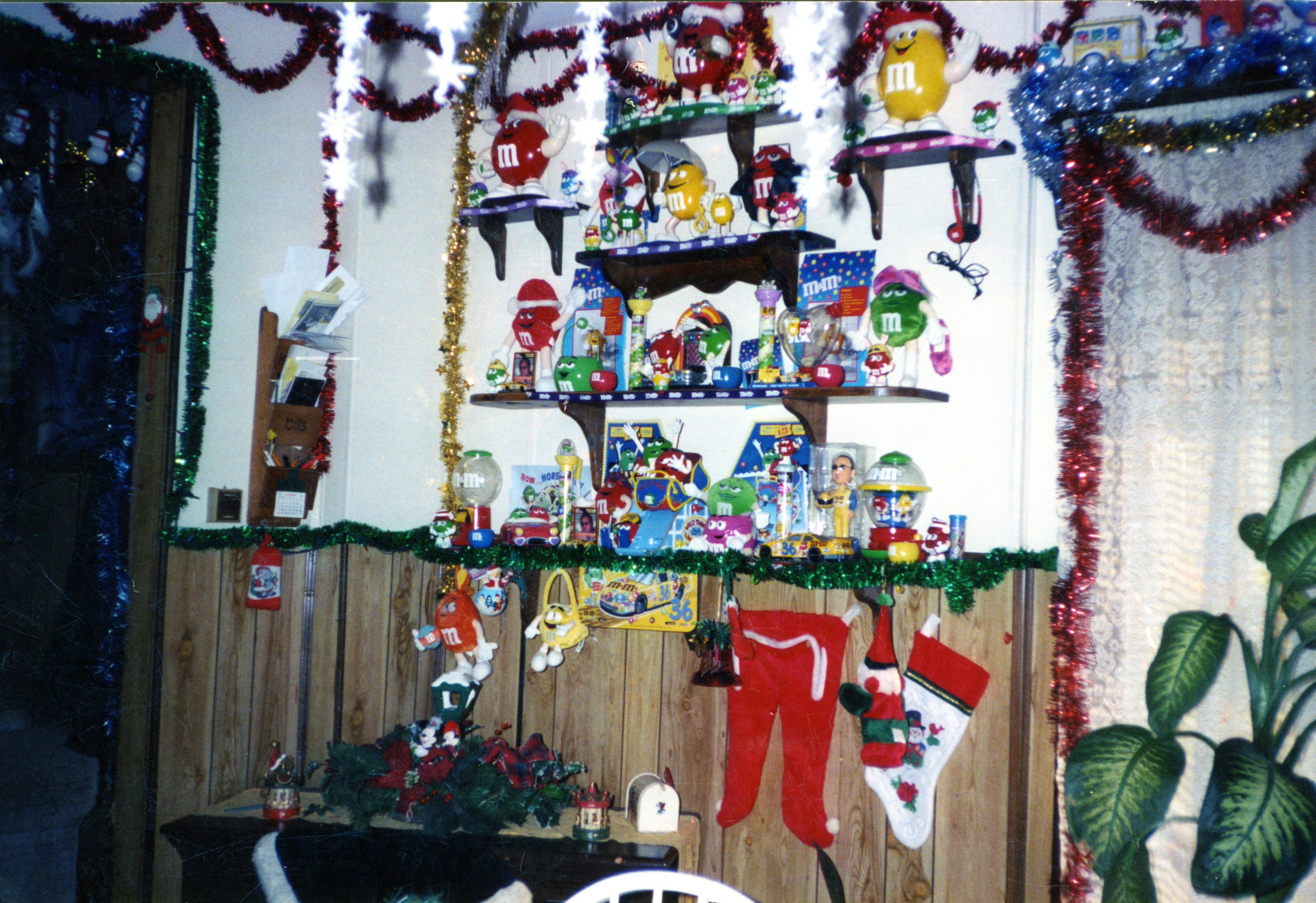 Festive wall decorated with numerous christmas items, stockings, and tinsel.