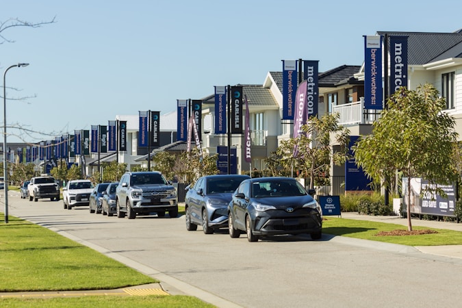 Modern single-family homes with cars parked along a quiet suburban street