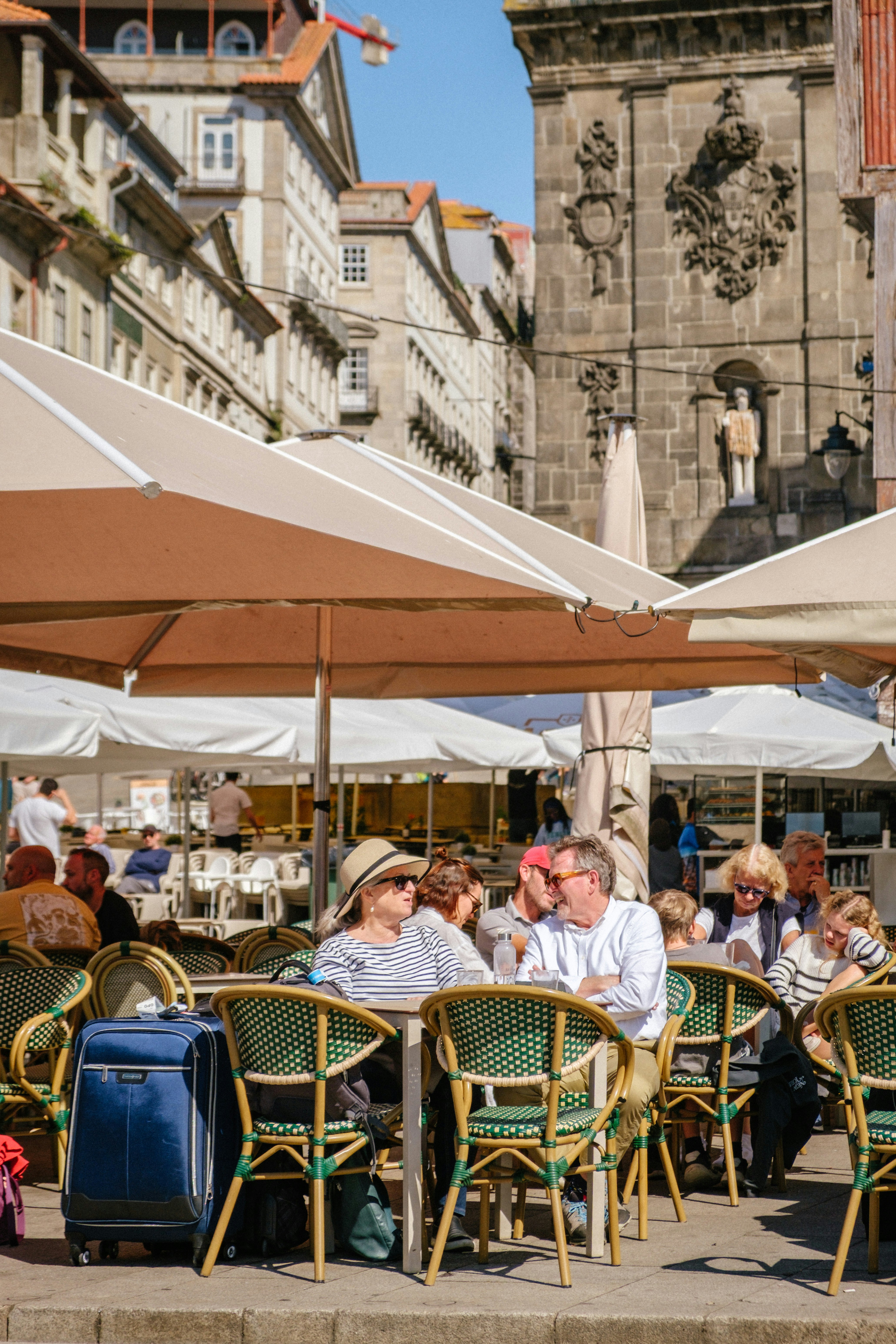 People sitting at outdoor cafe with historic buildings