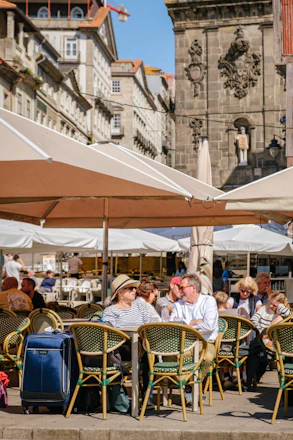 People sitting at outdoor cafe with historic buildings