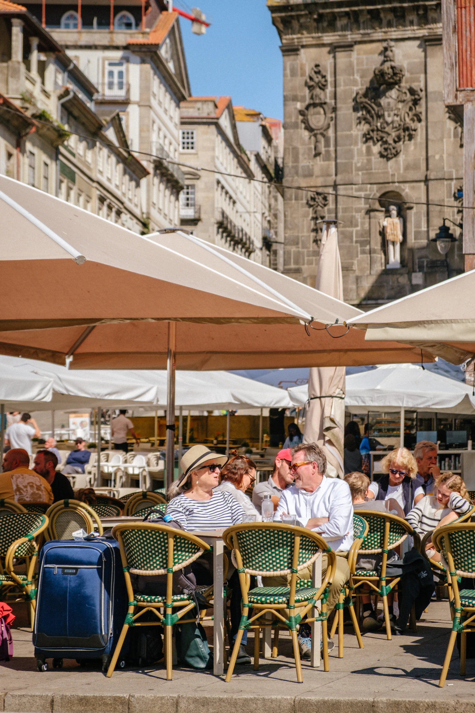 Esplanada com mesas, cadeiras e guarda-sóis no centro do Porto