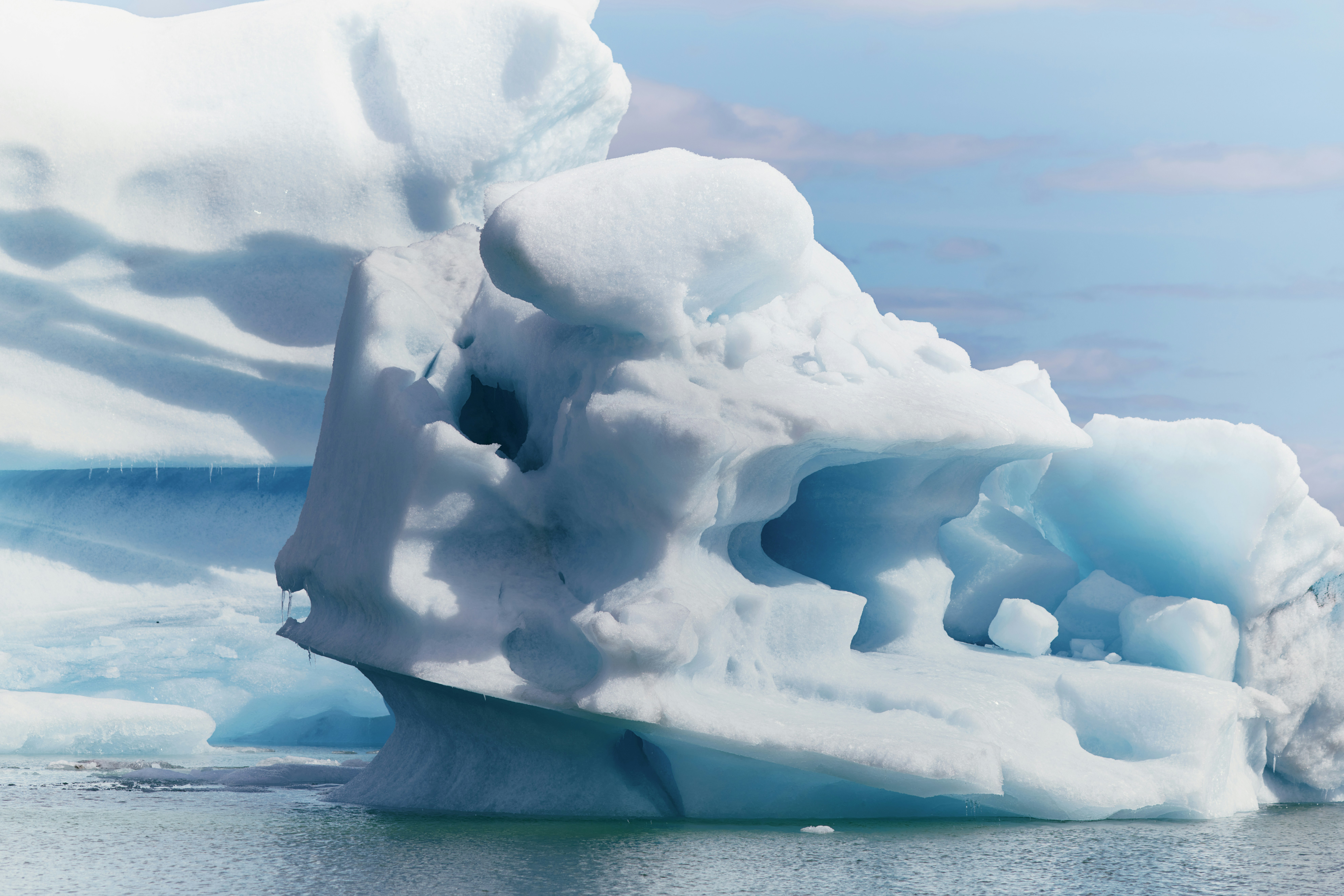 Blue iceberg with intricate shapes floating in water