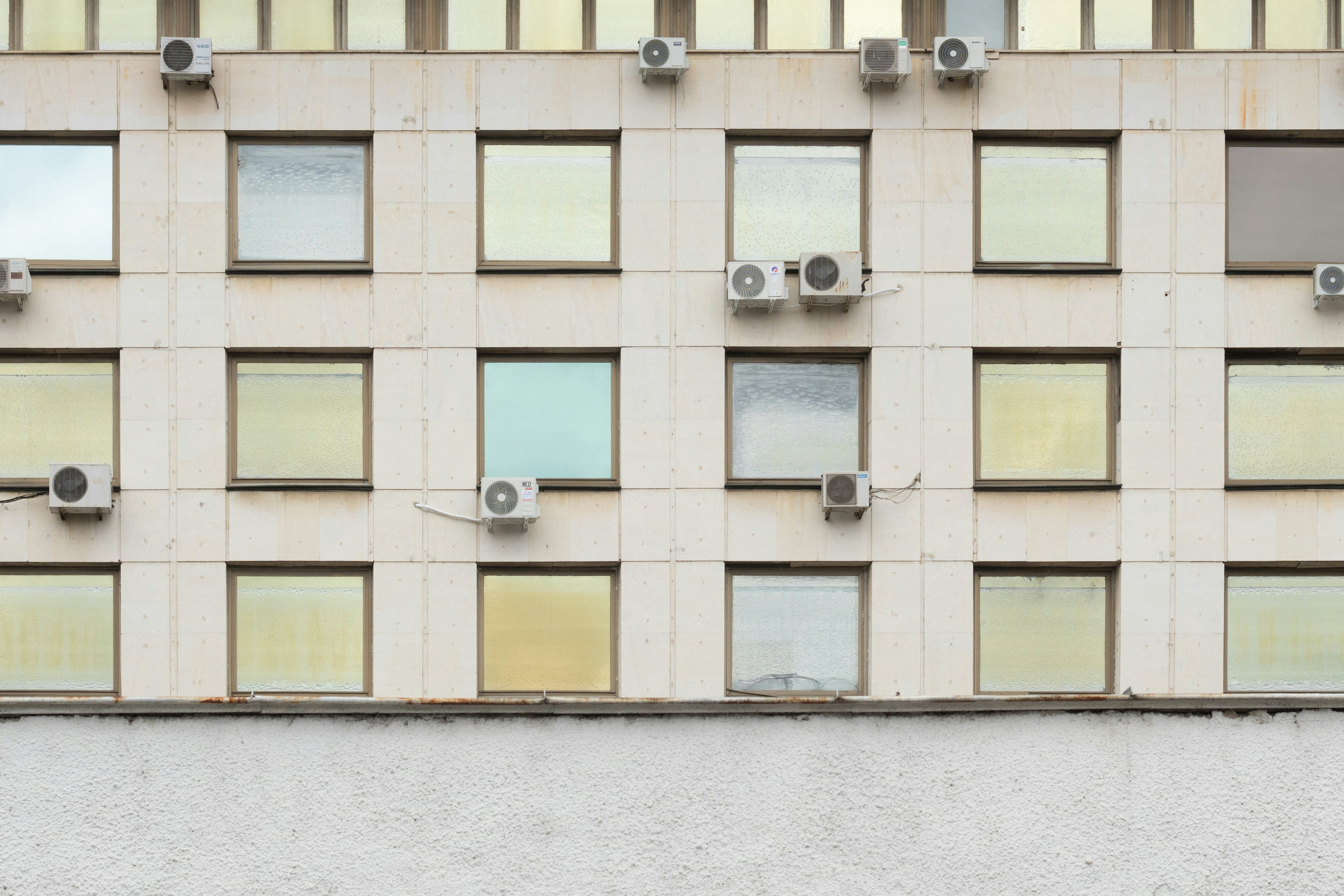 Building exterior with square windows and multiple air conditioners